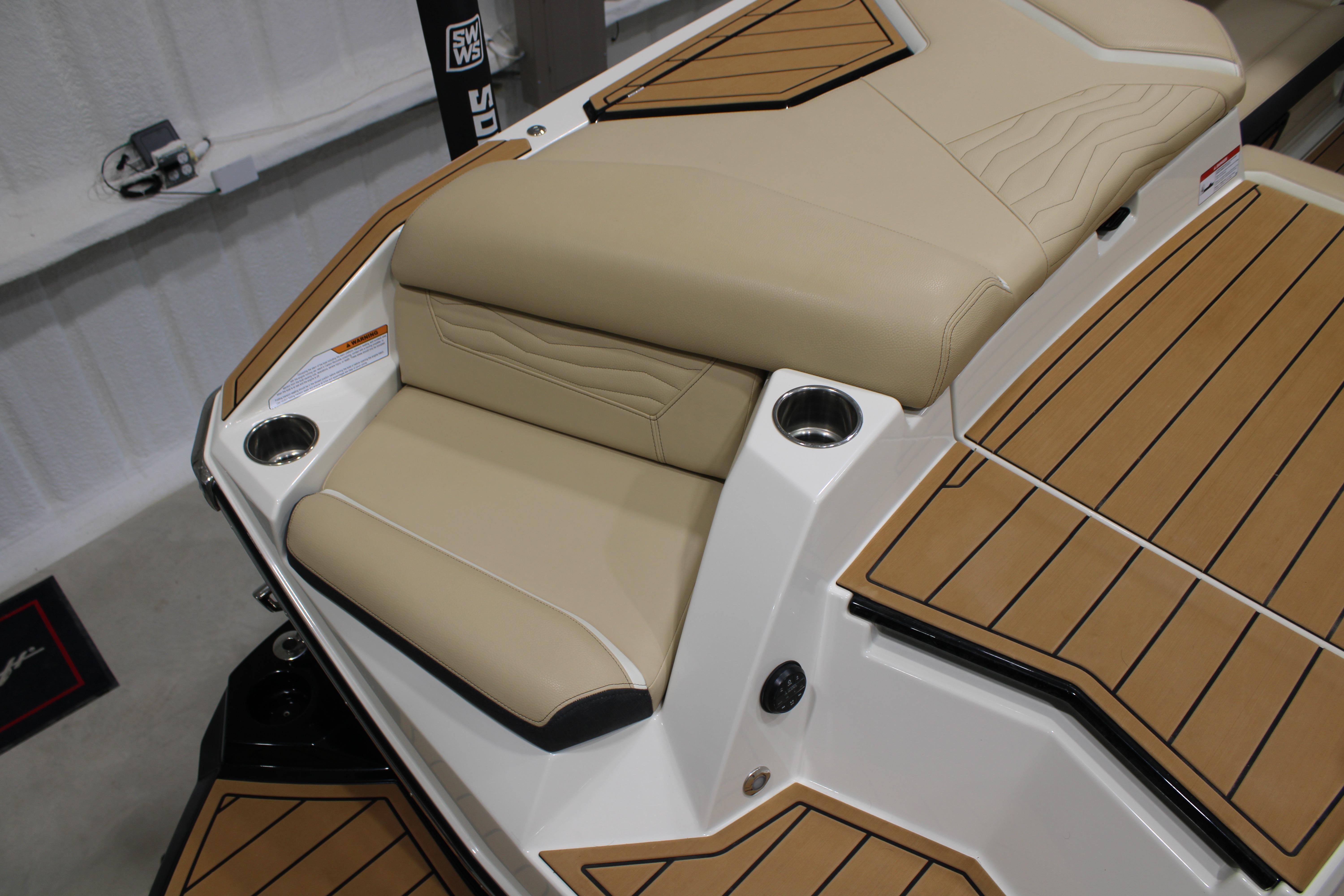 2025 Nautique Super Air Nautique G25 boat interior with beige seating and cup holders.