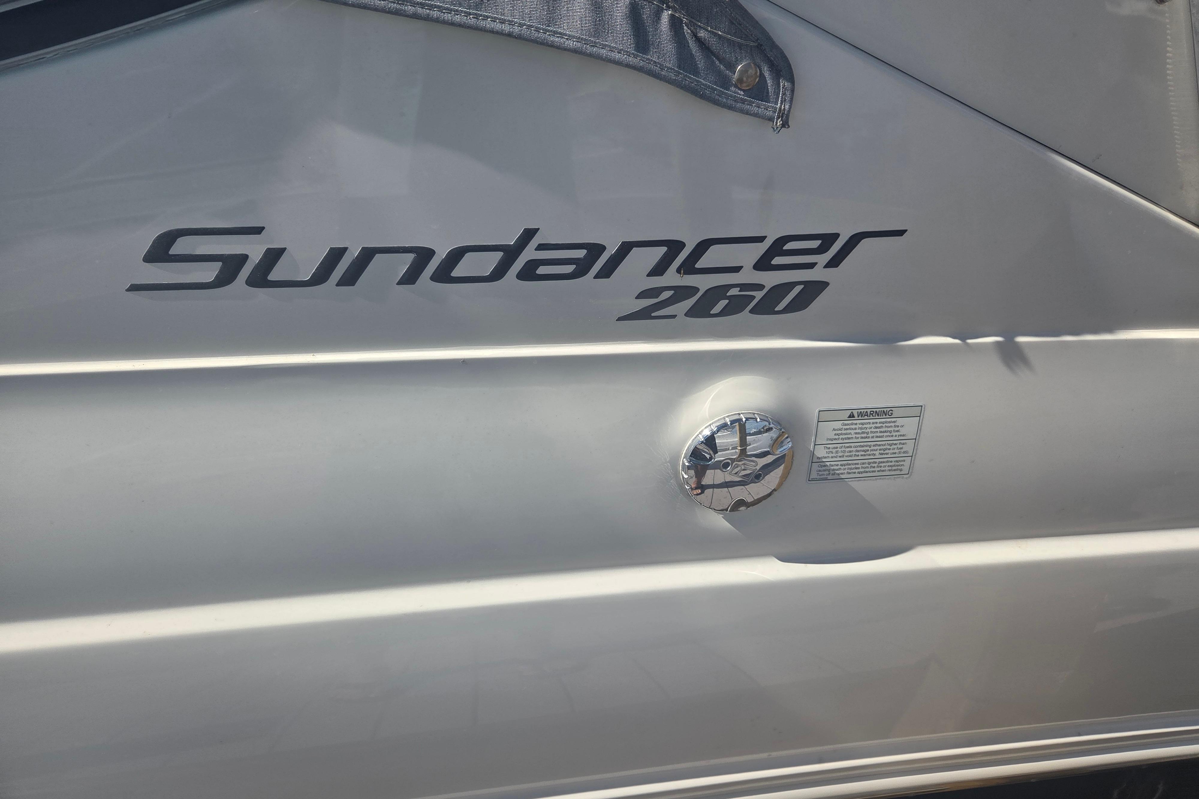2012 Sea Ray Sundancer 260 boat exterior with model name and warning label.