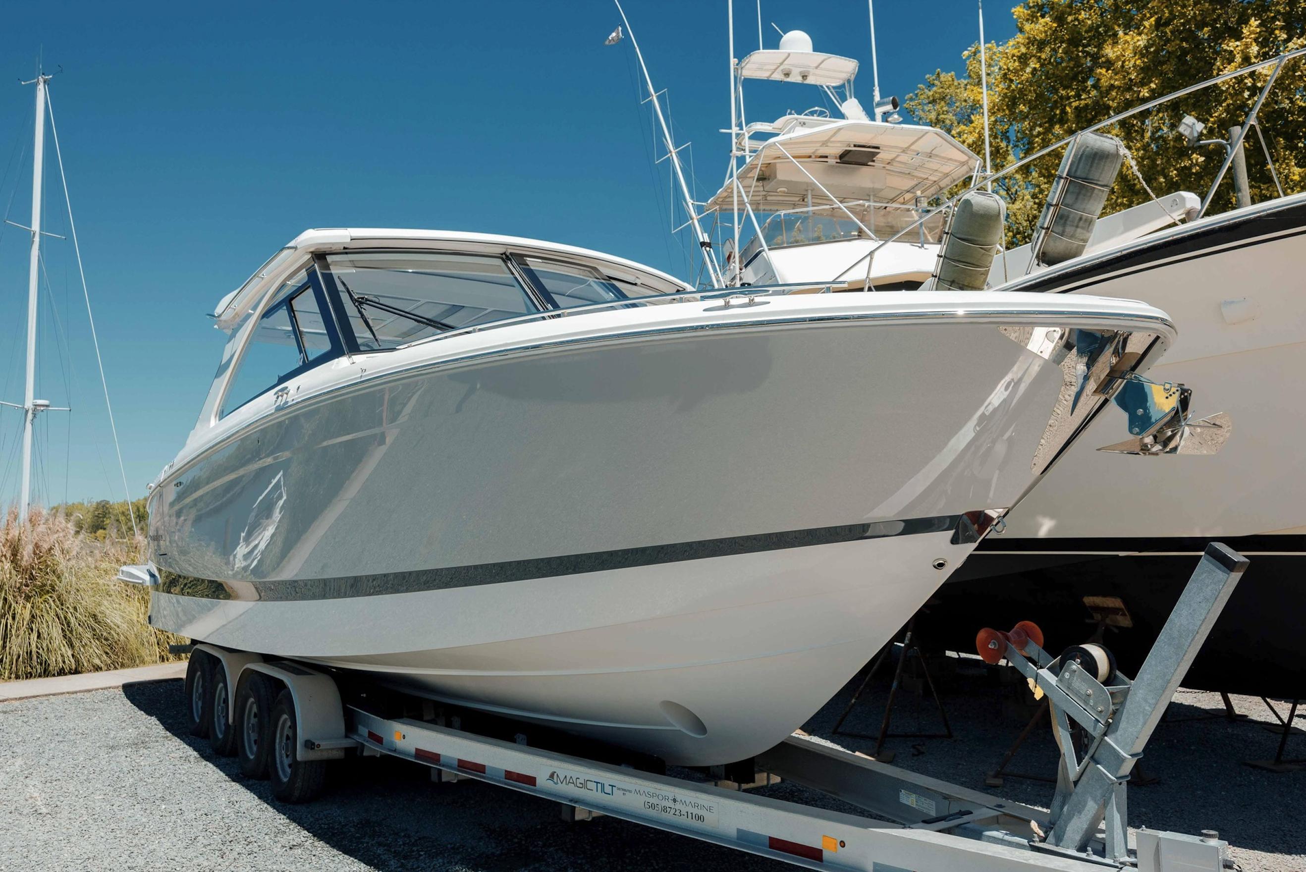 2022 Regal LX36 boat on trailer, parked outdoors under clear blue sky.