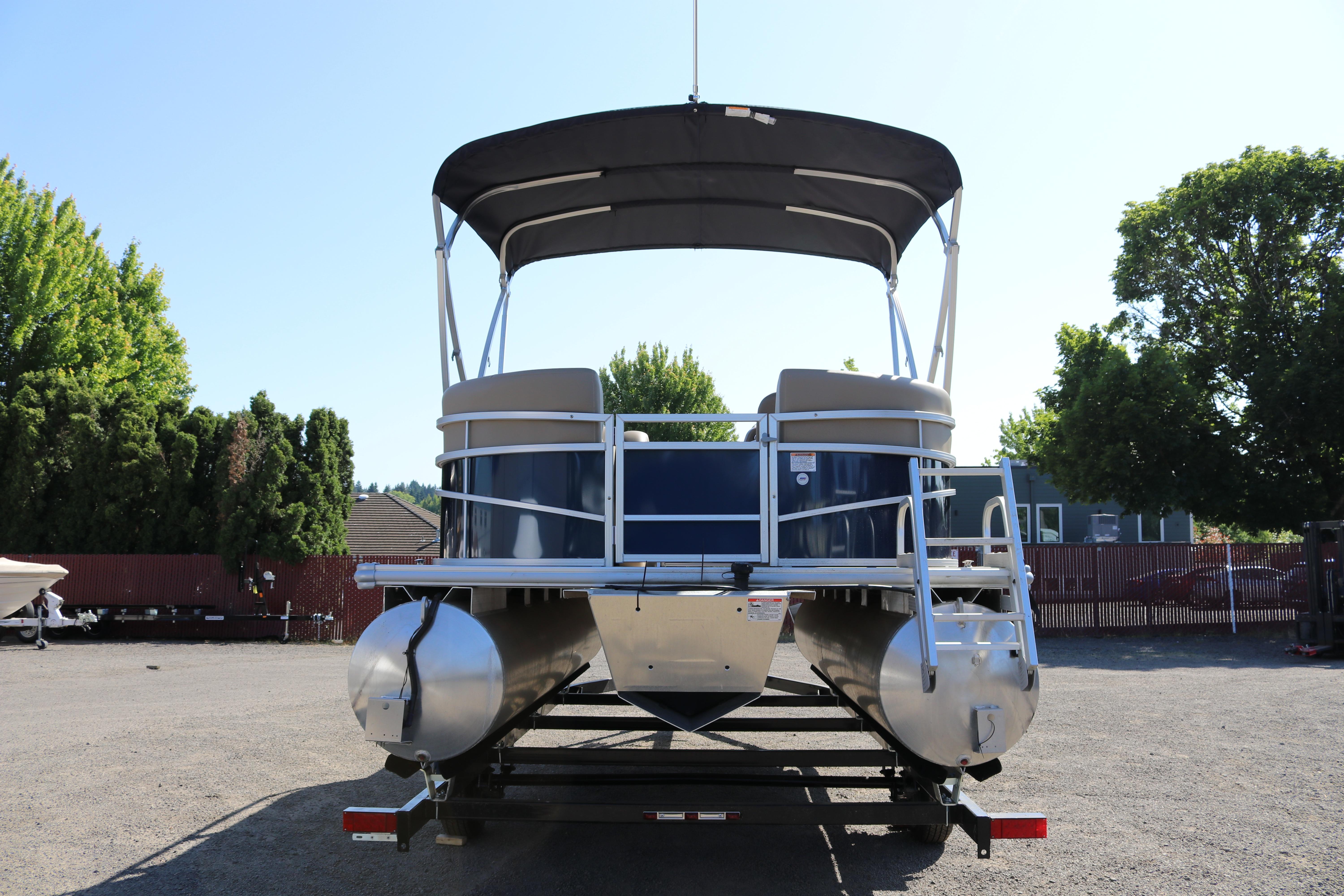 2025 Sun Chaser Vista Fish 18 pontoon boat with canopy, parked outdoors.