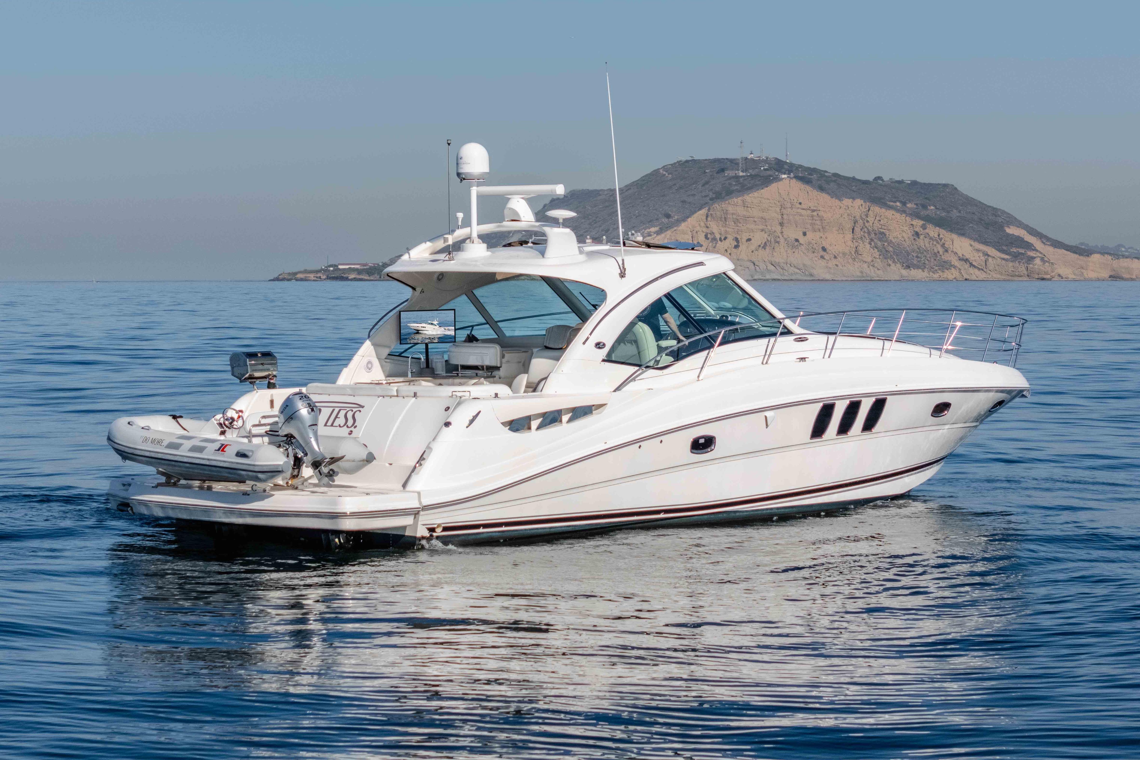 2007 Sea Ray 48 Sundancer yacht cruising on calm waters near a scenic island backdrop.