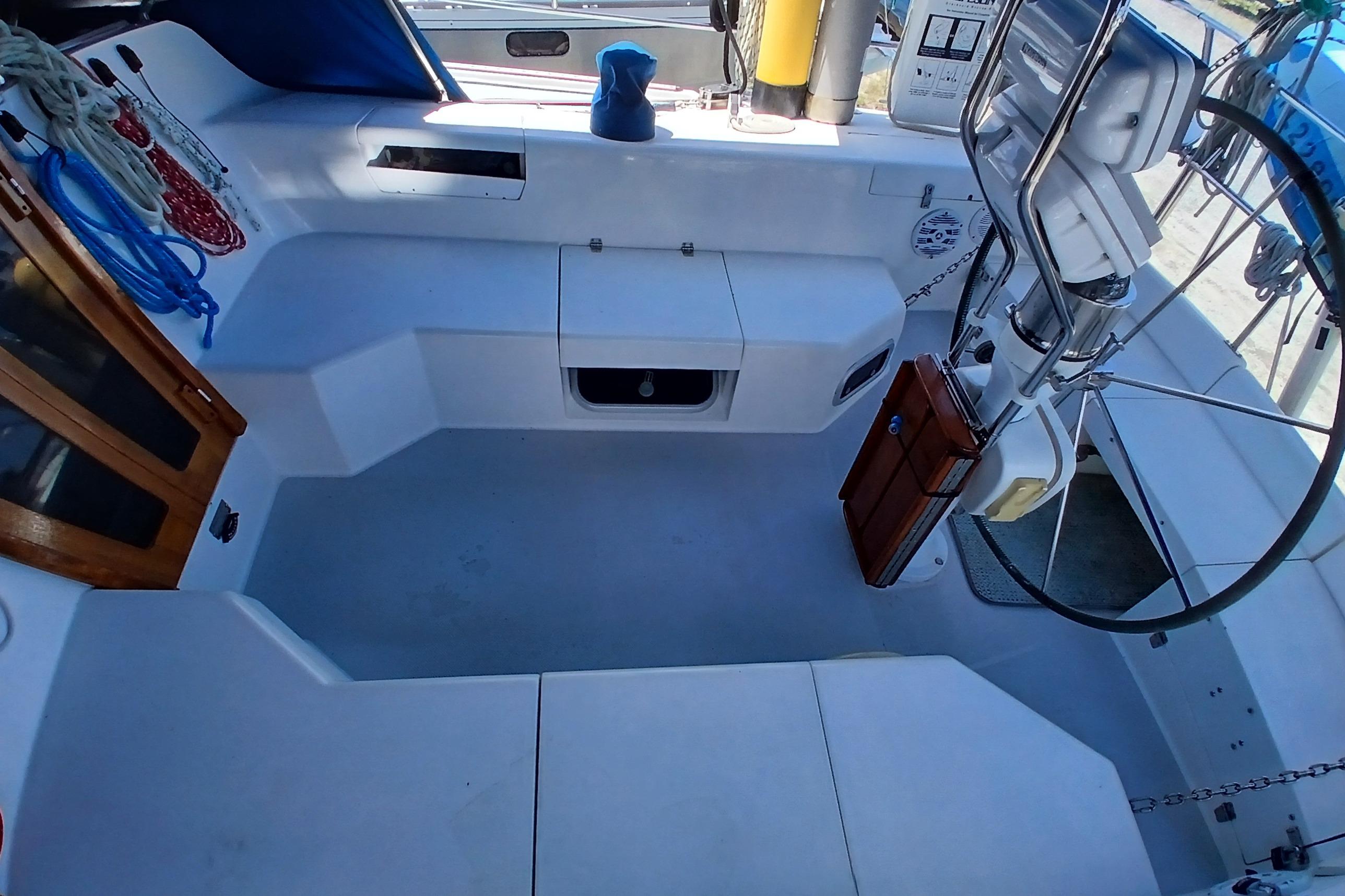 Cockpit of a 1995 Catalina 42 MkII sailboat with steering wheel and seating.