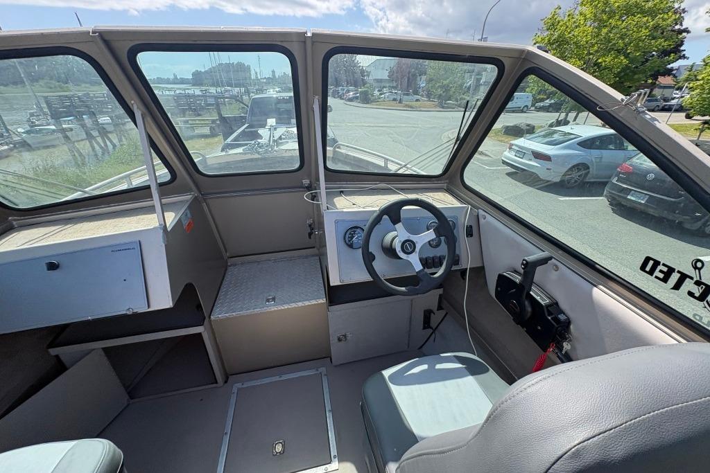2009 Alumaweld Intruder Outboard 22 boat interior with steering wheel and dashboard view.
