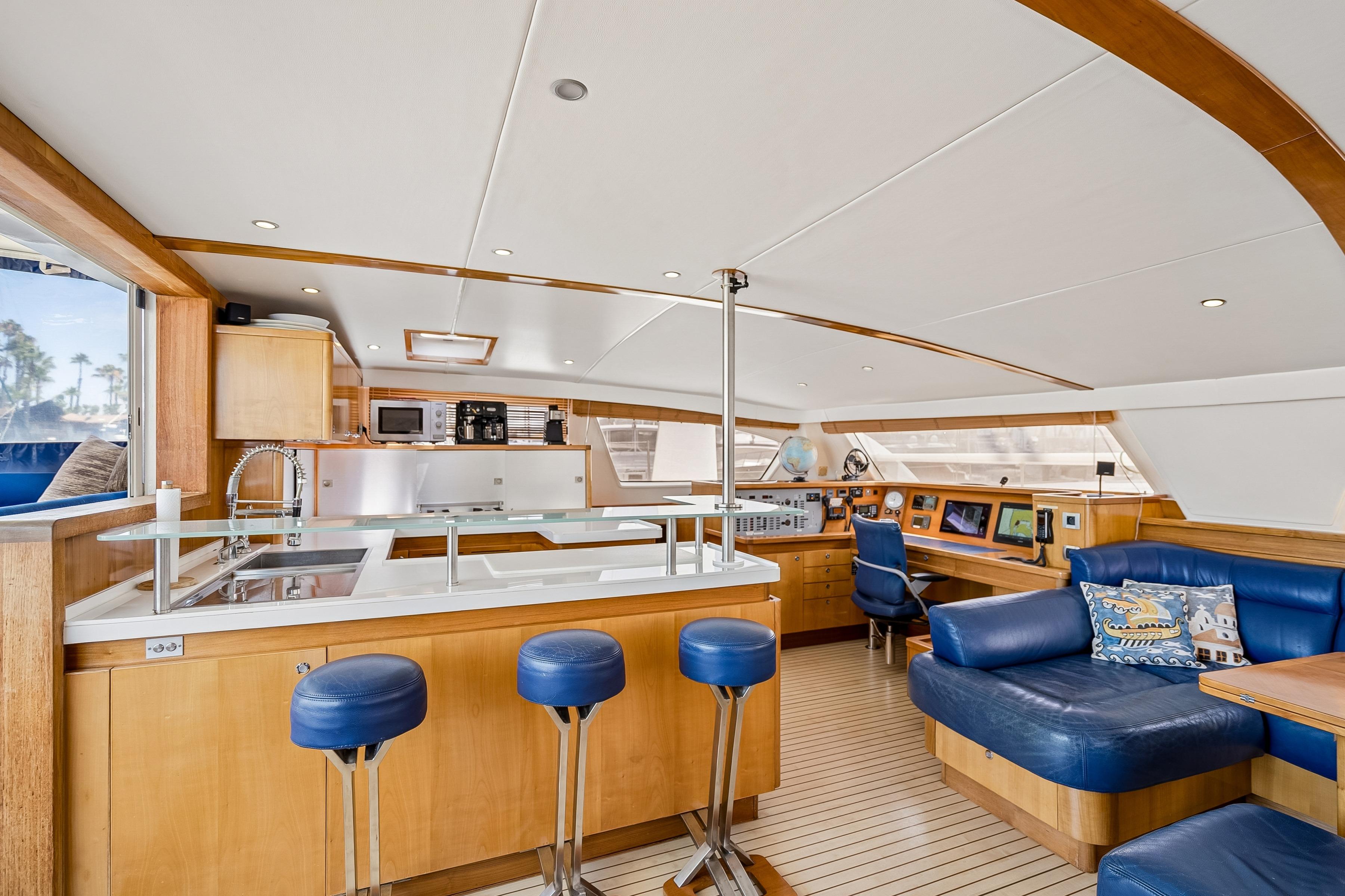 Luxurious interior of 2009 Catana 65 yacht with modern kitchen and blue seating.