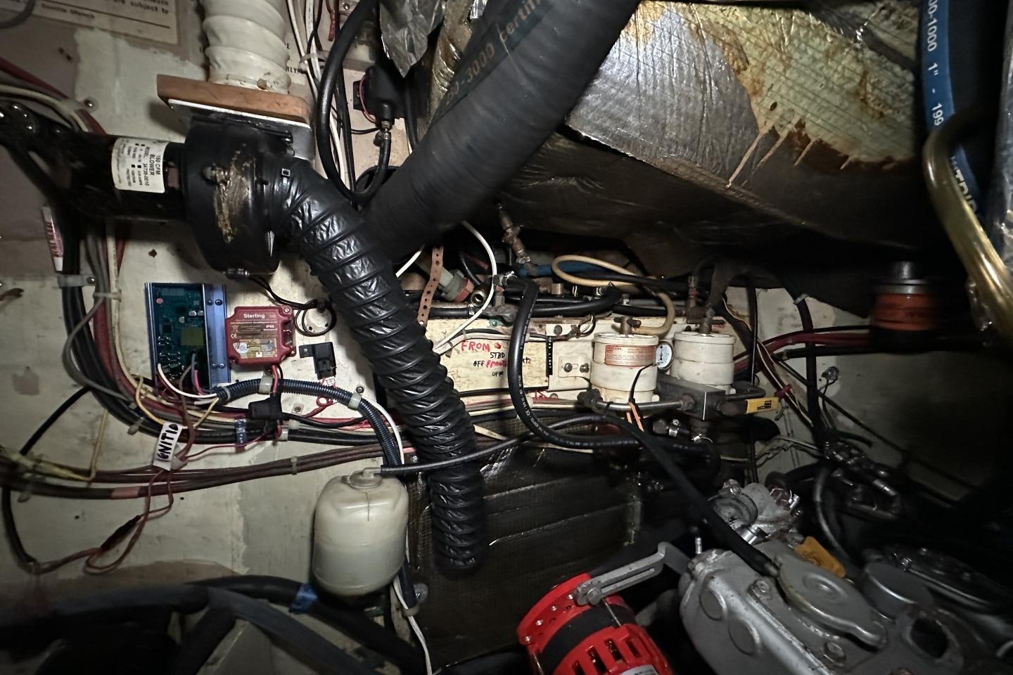 Engine room of a 1976 Valiant 40 sailboat, showcasing wiring and mechanical components.