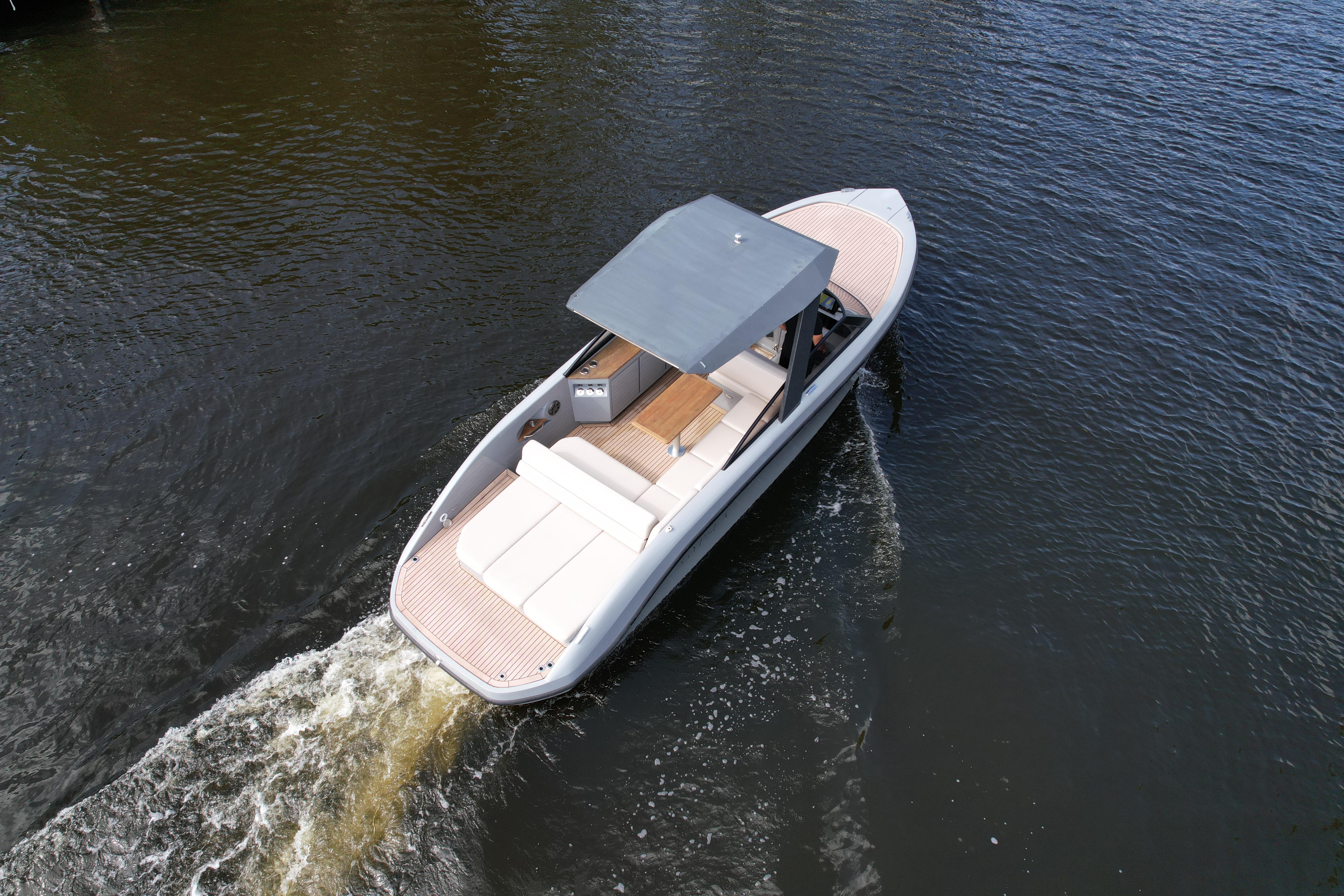 2021 Rand Leisure boat cruising on calm water, featuring sleek design and spacious deck.