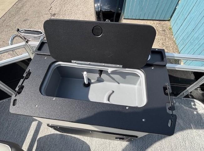 2026 Sun Tracker Fishin' Barge 20 DLX livewell, open lid, gray interior, black trim.