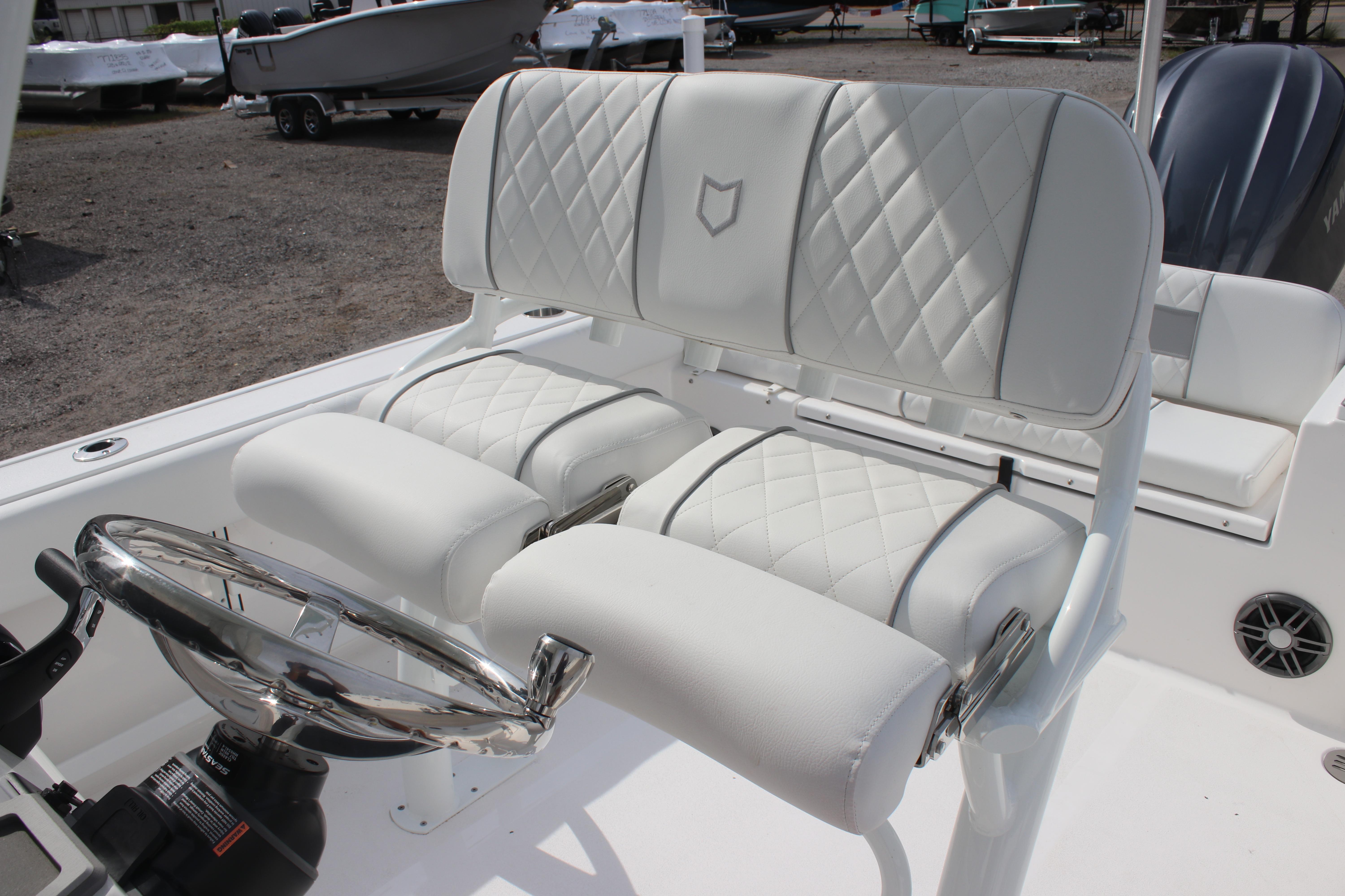 2026 Sea Fox 248 Commander boat with white quilted seating and chrome steering wheel.