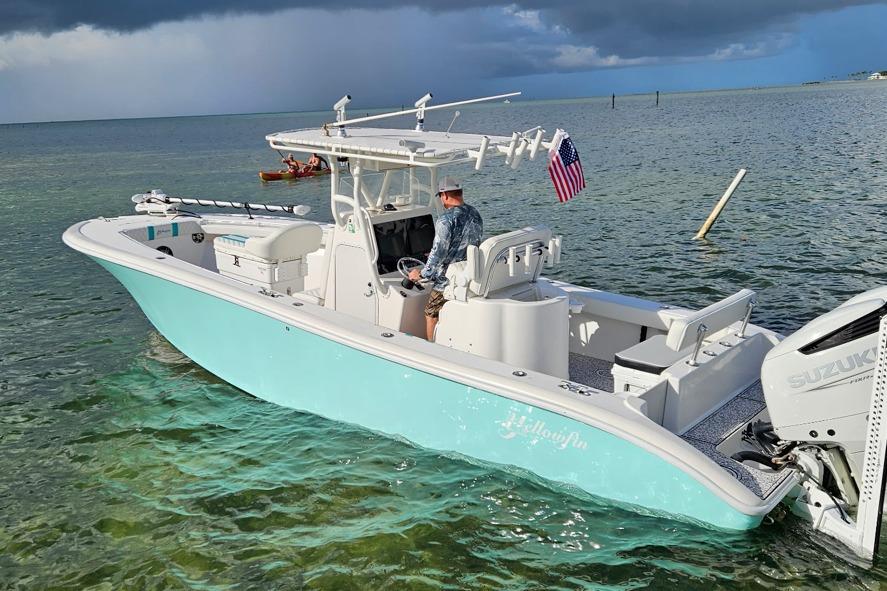 2002 Yellowfin 31 Center Console boat on clear water, American flag, Suzuki engine.