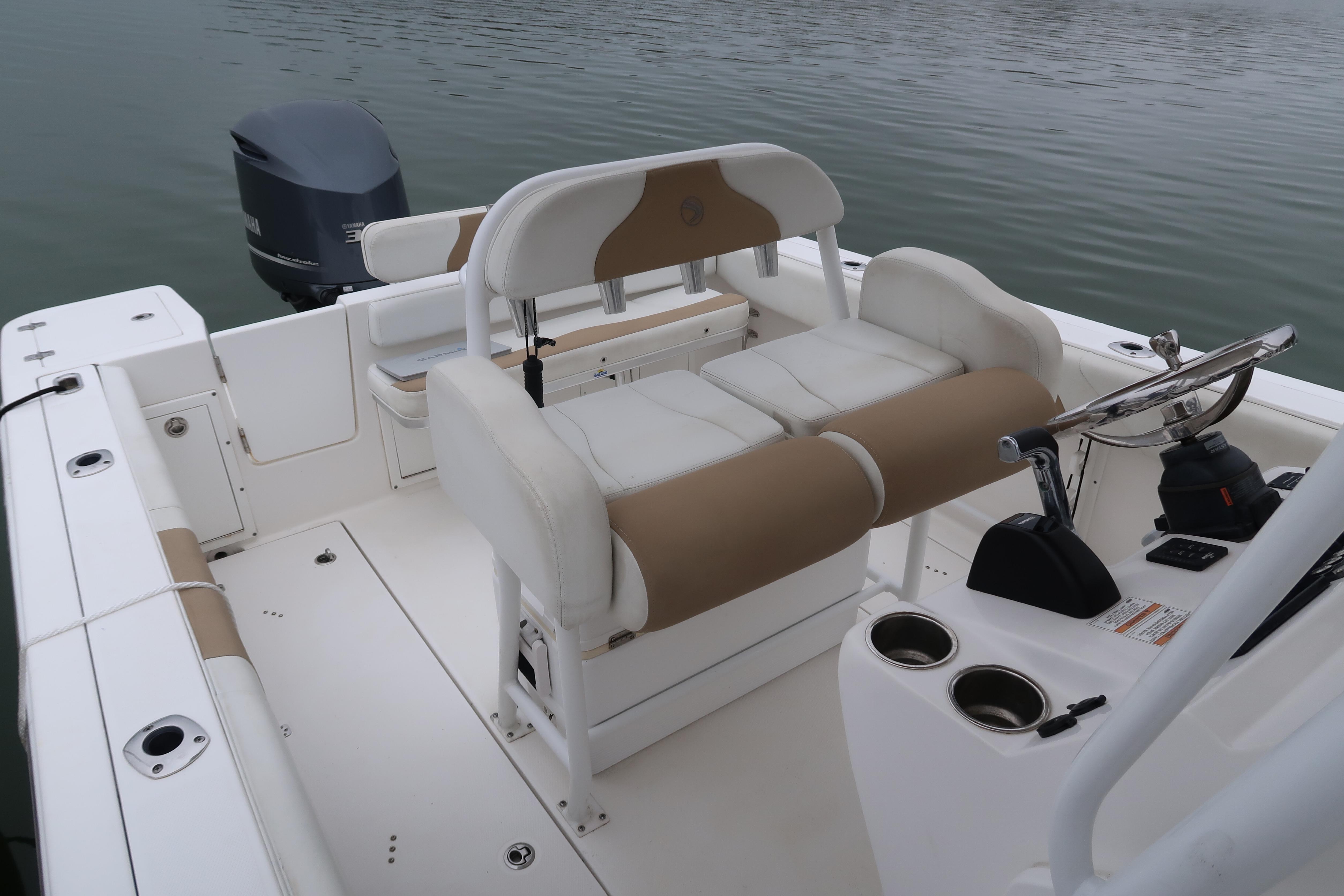 Edgewater 245CC 2017 boat interior with seating and steering wheel on calm water.