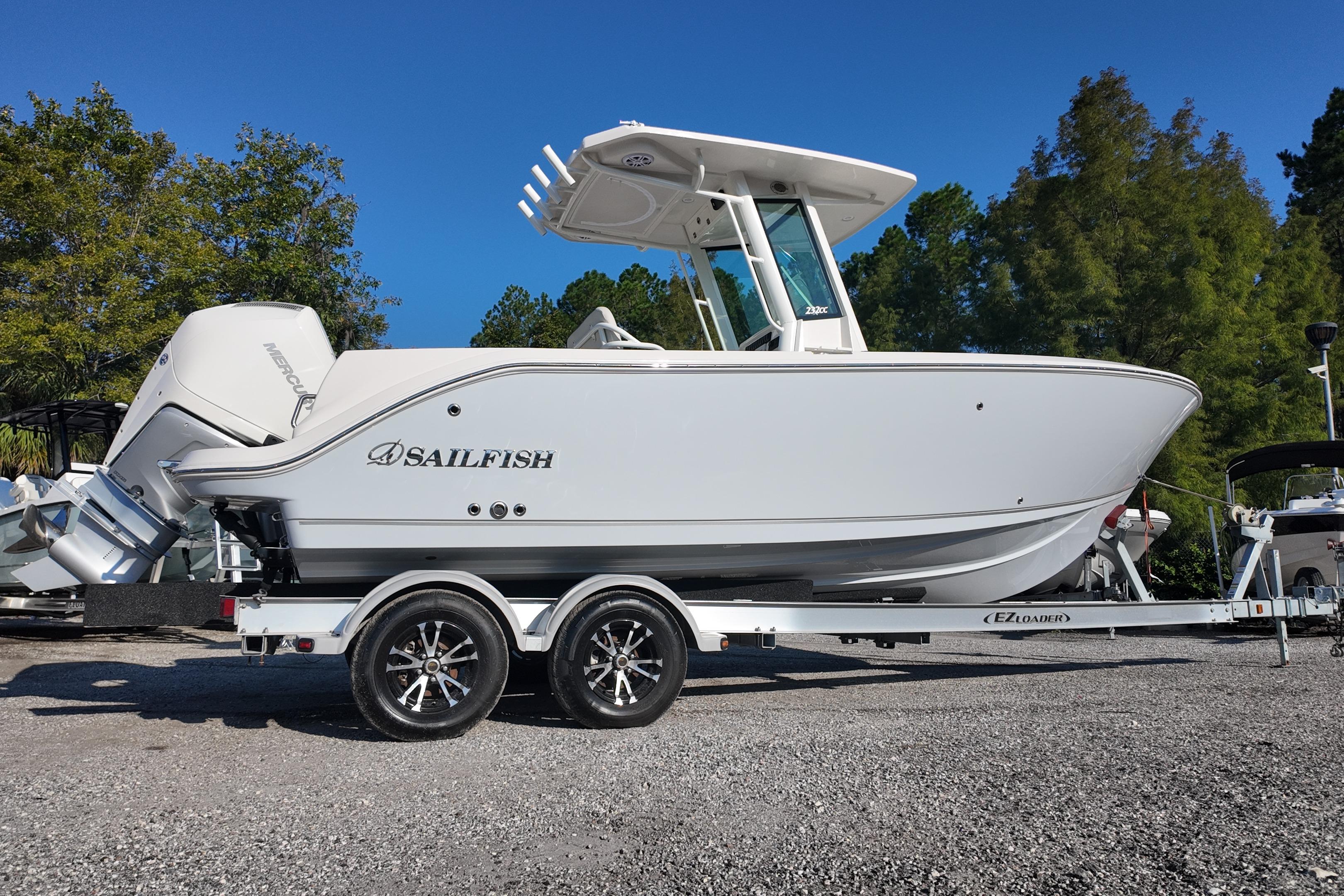 2026 Sailfish 232 CC boat on trailer, side view, outdoors with trees in background.