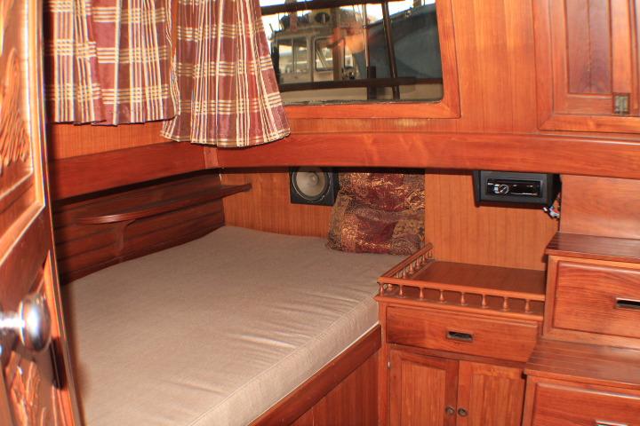 1977 CHB Double Cabin interior with wooden furnishings and cozy bed.