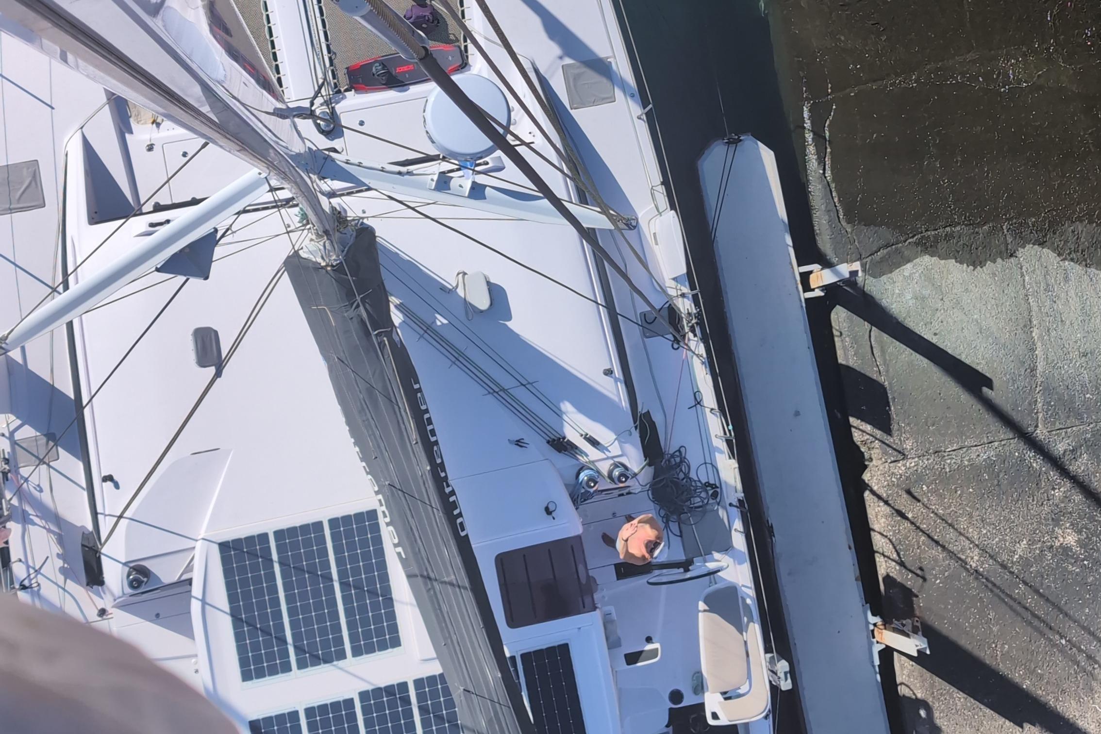 Aerial view of 2024 Outremer 52 catamaran with solar panels and docked at a marina.