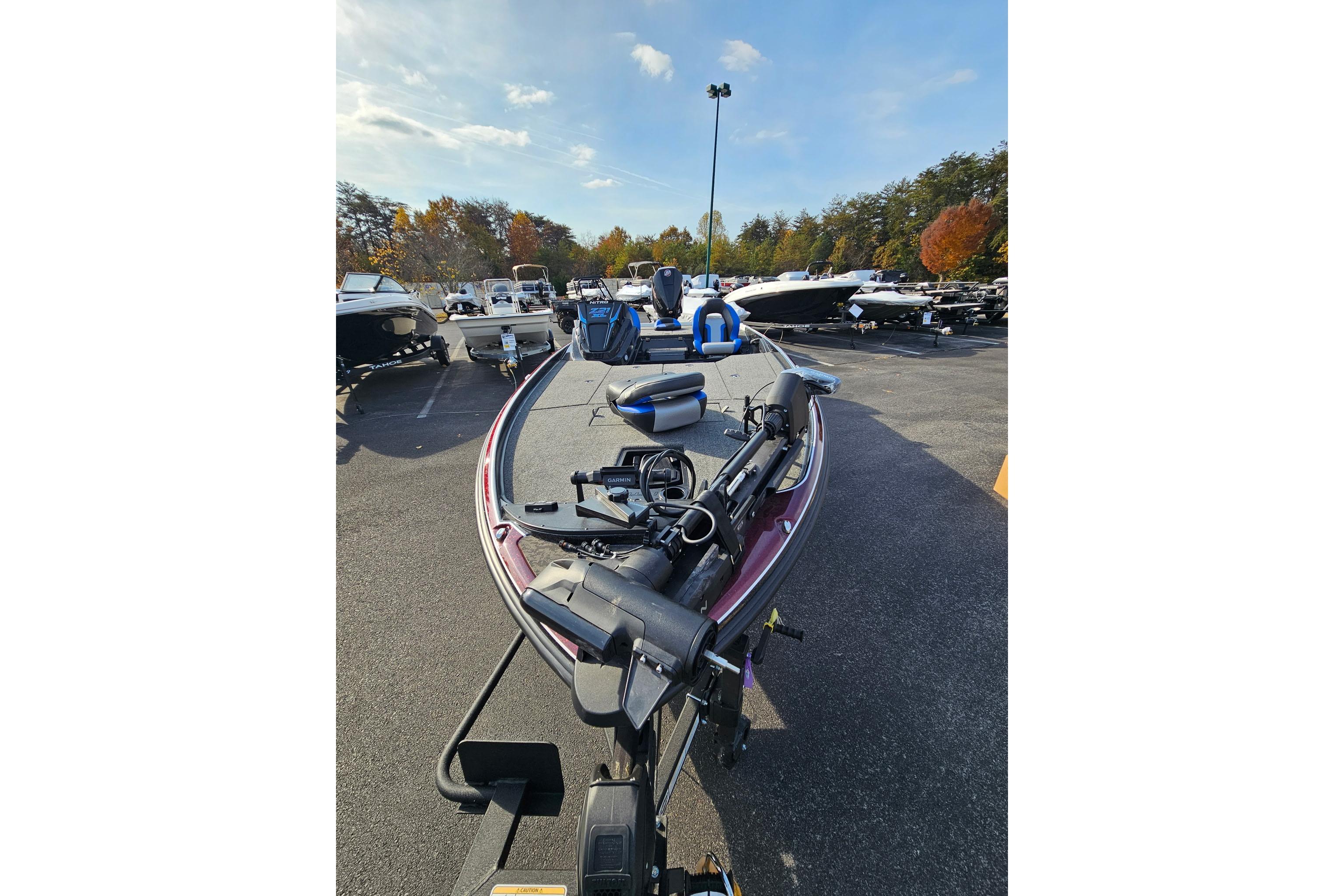2026 Nitro Z21 XL Pro boat in parking lot, surrounded by trees and other boats.