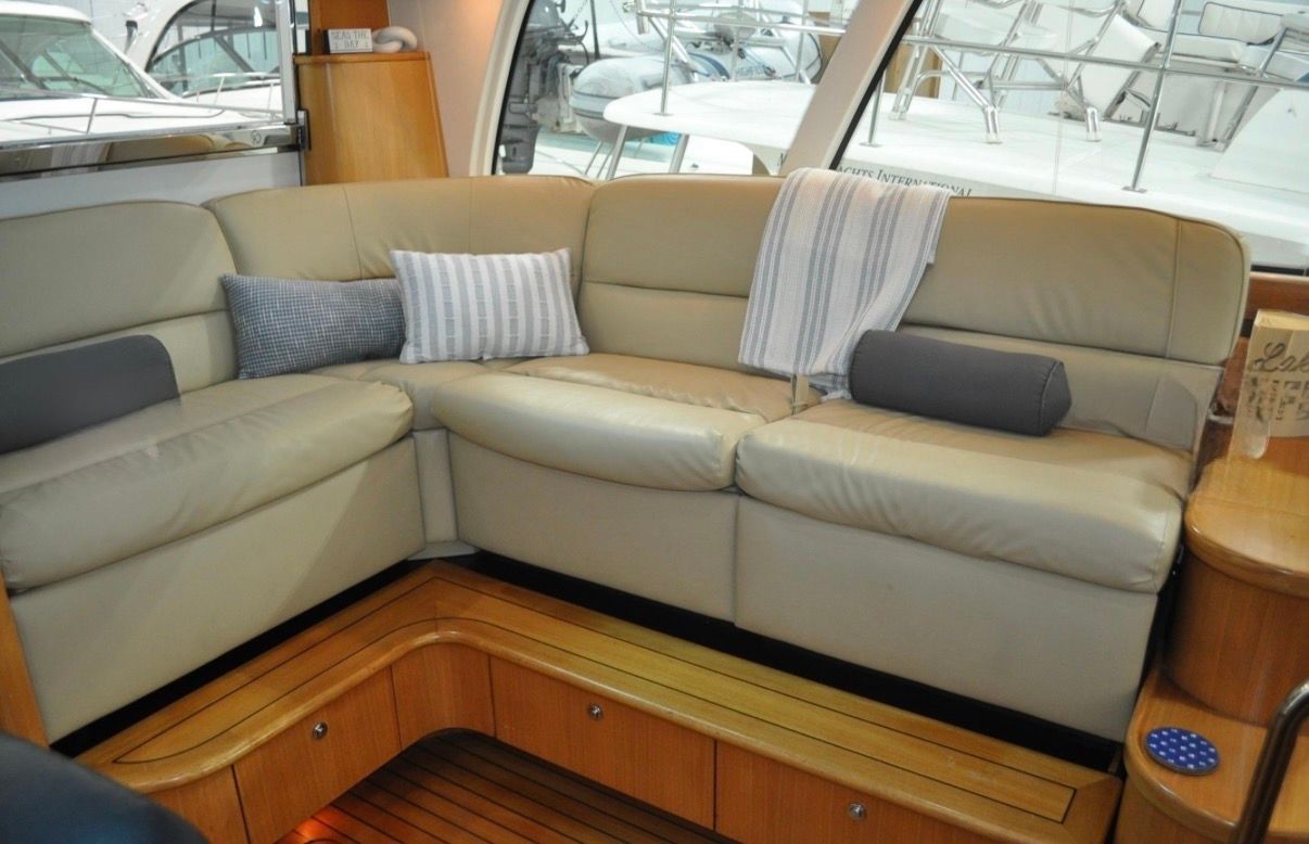 Interior of the 2005 Tiara Yachts 5200 Sovran with beige leather sofa and wooden flooring.