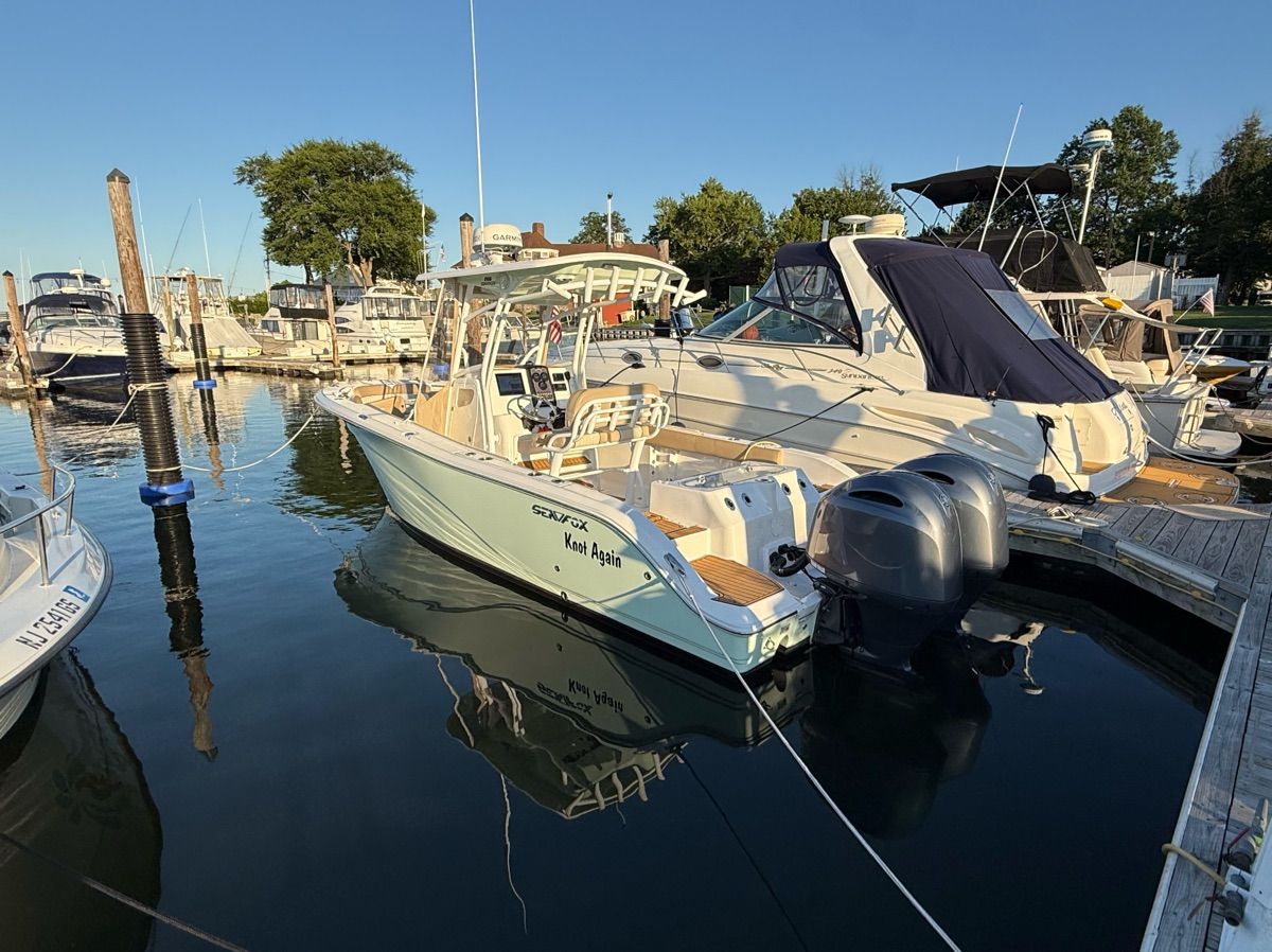 A 2017 Sea Fox Commander 266 docked in a calm marina.