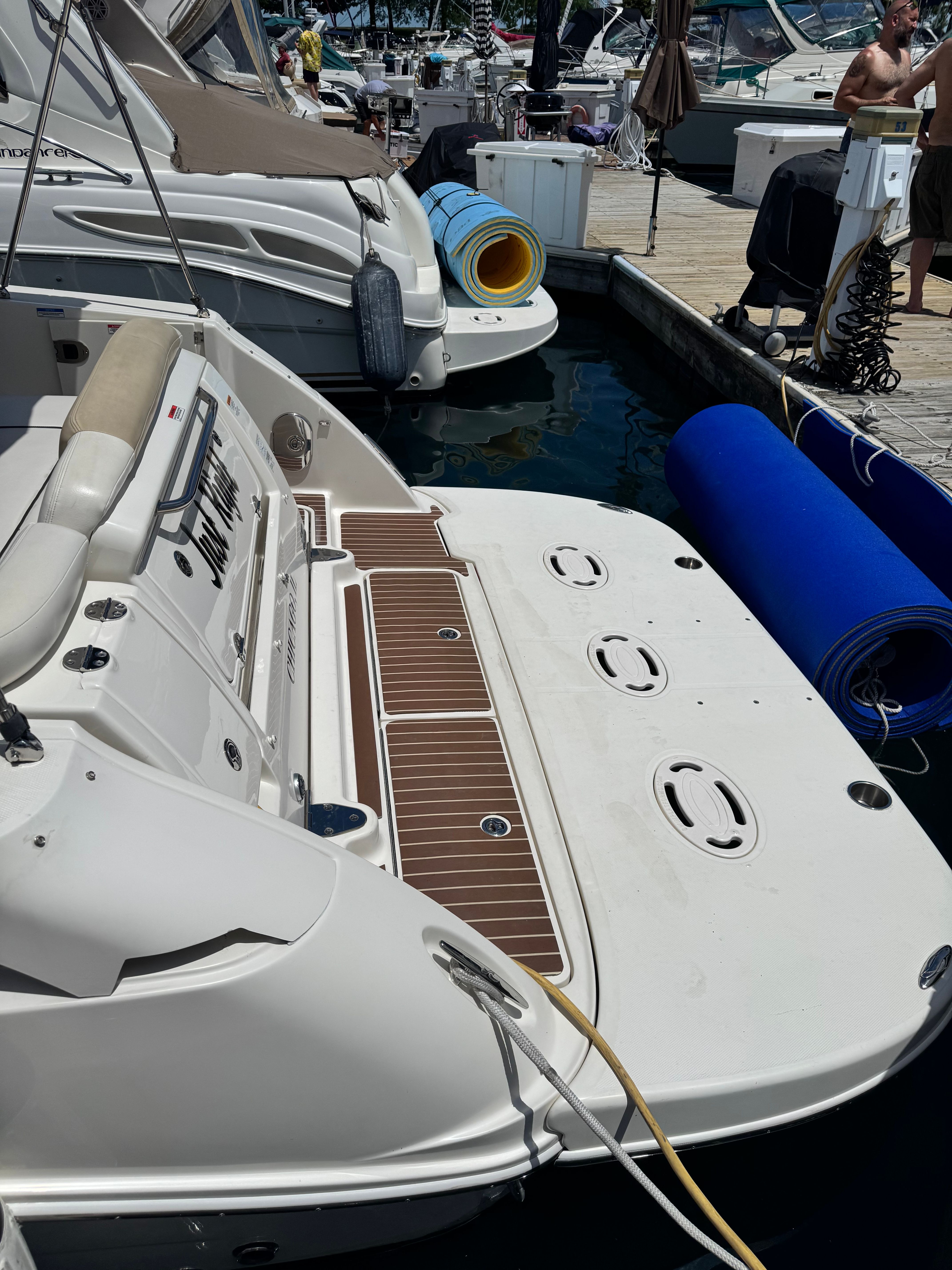 The image shows the stern of a 2010 Sea Ray Sundancer 310 docked at a marina.
