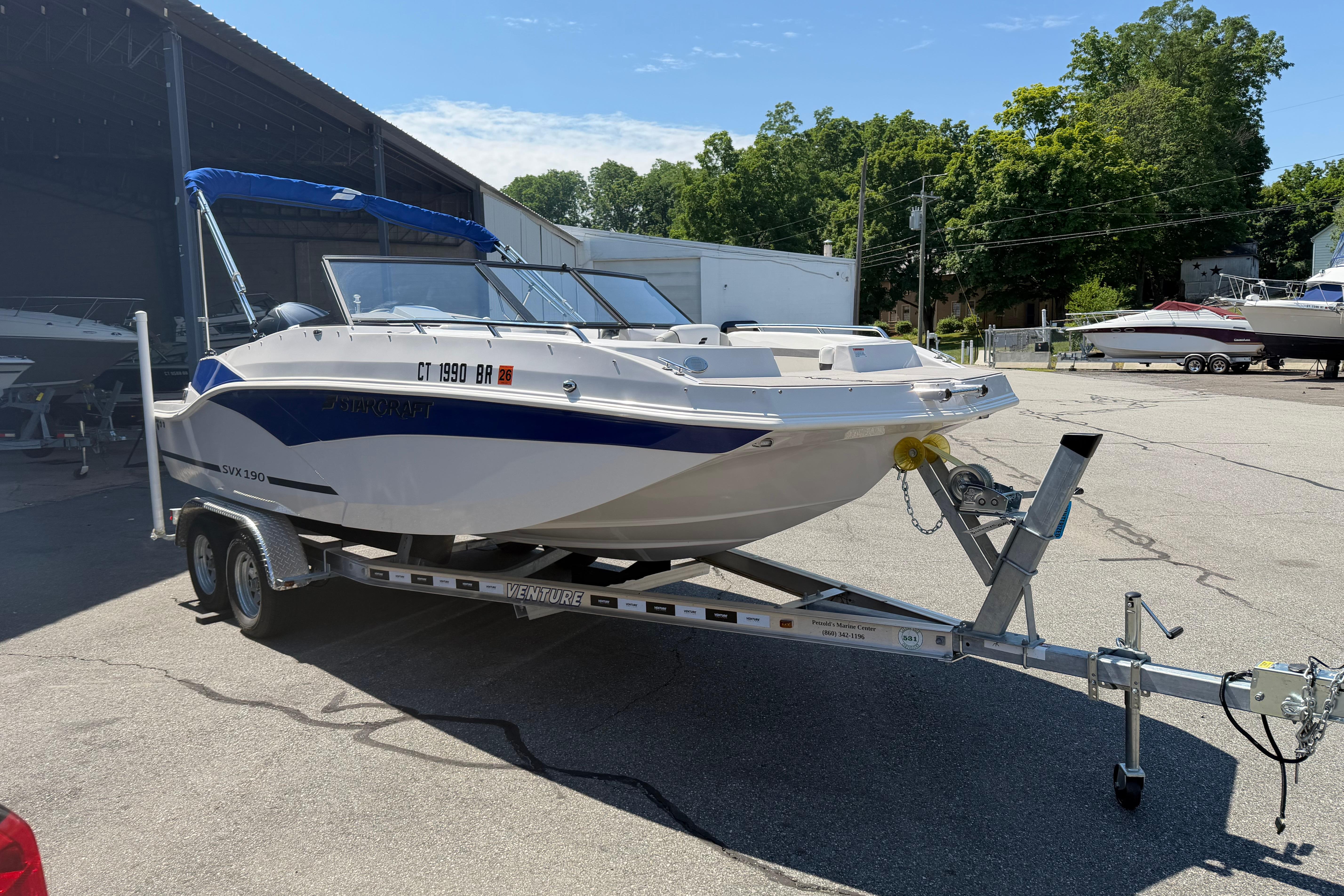 2025 Starcraft SVX 190 OB boat on trailer, parked outdoors under clear sky.