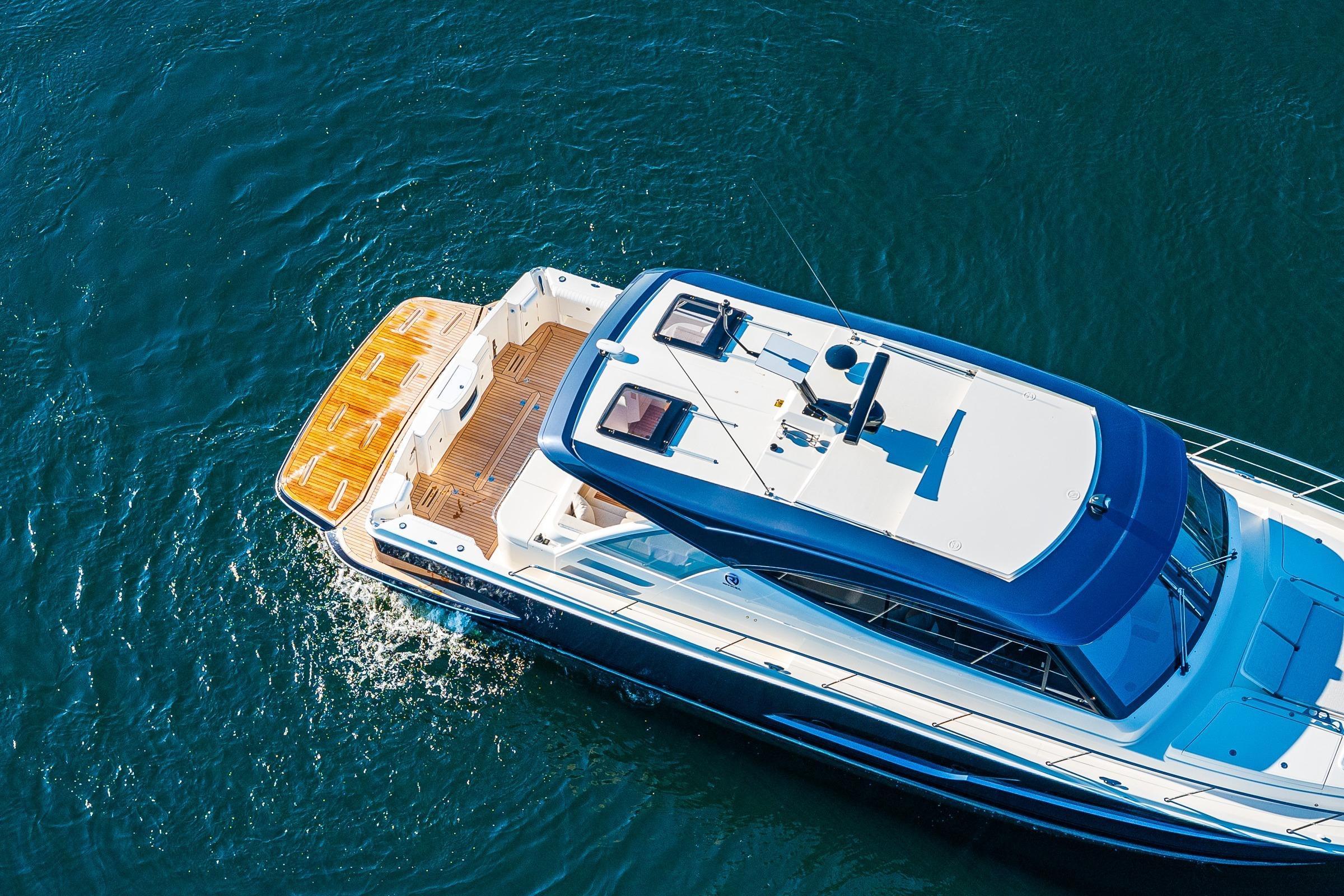 Aerial view of 2026 Riviera 505 SUV yacht cruising on blue water.