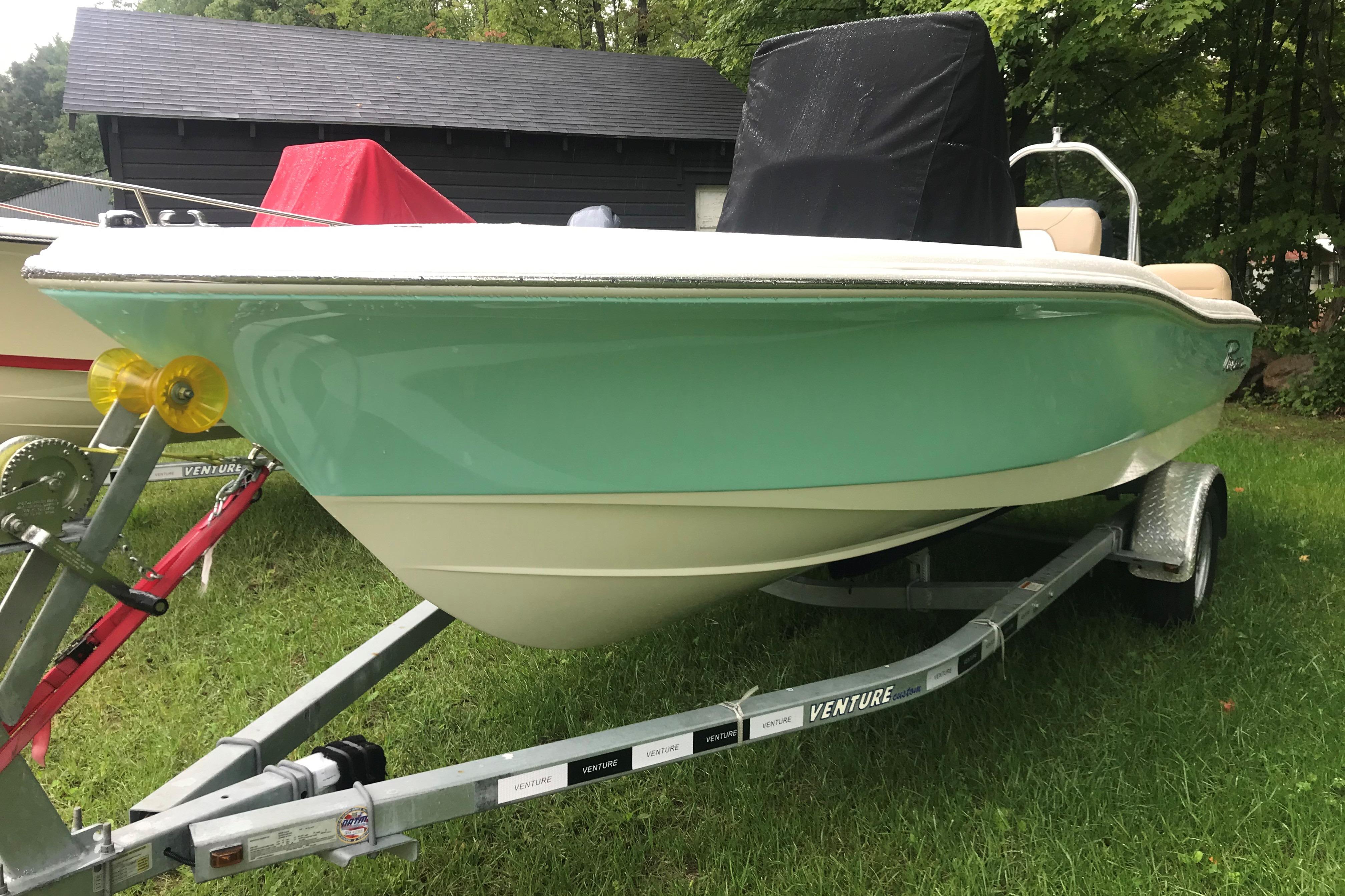 2026 Pioneer 180 Islander boat on trailer, green hull, parked on grass.