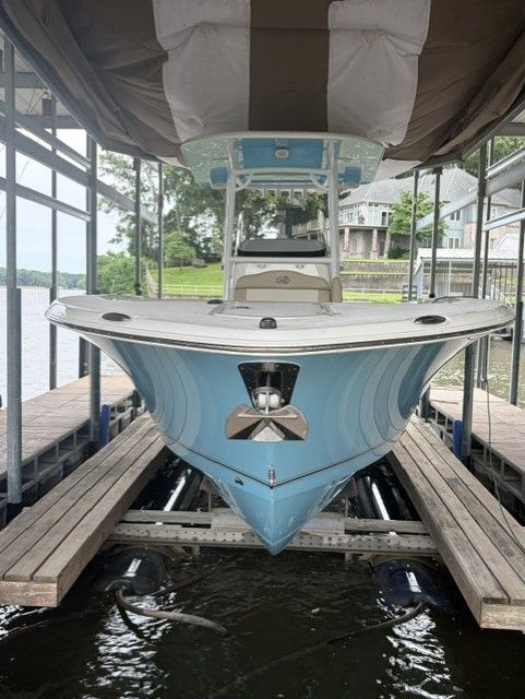 A blue NauticStar 28 boat, 2018 model, is docked under a covered area.