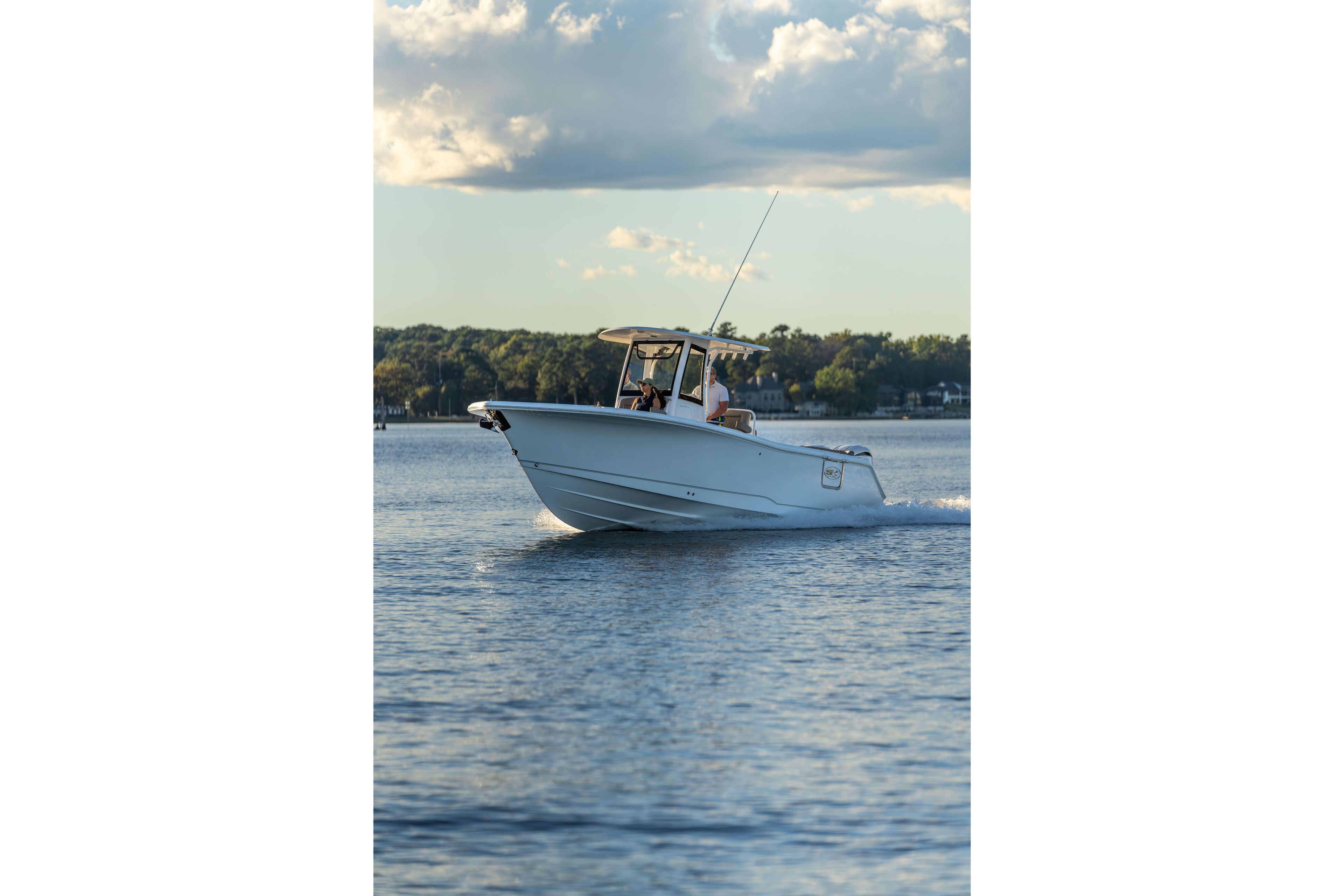 2026 Sea Hunt Ultra 275 Coffin Box cruising on a serene lake under a cloudy sky.