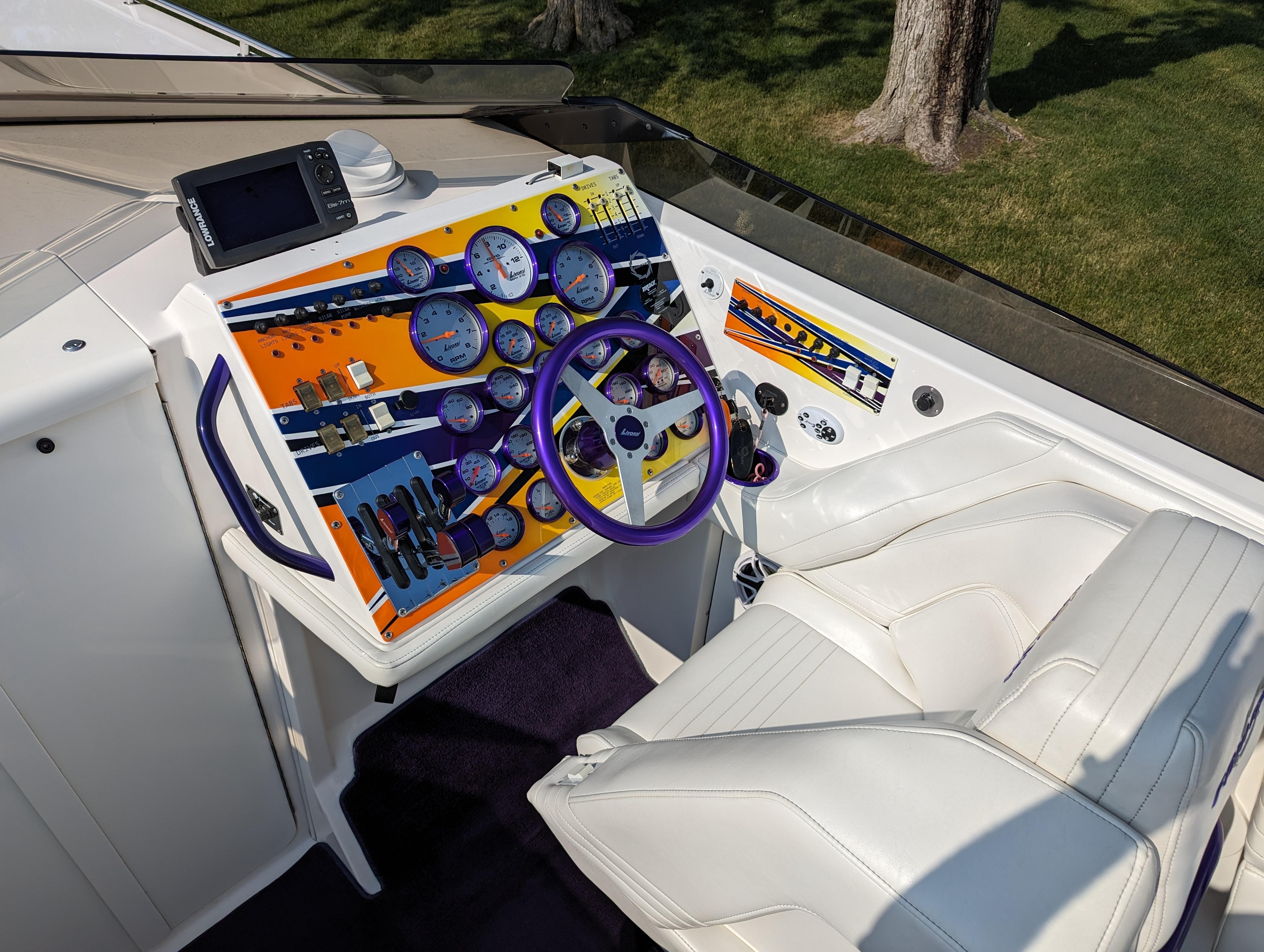 Cockpit of 2006 Fountain 42 boat with colorful dashboard and white seating.