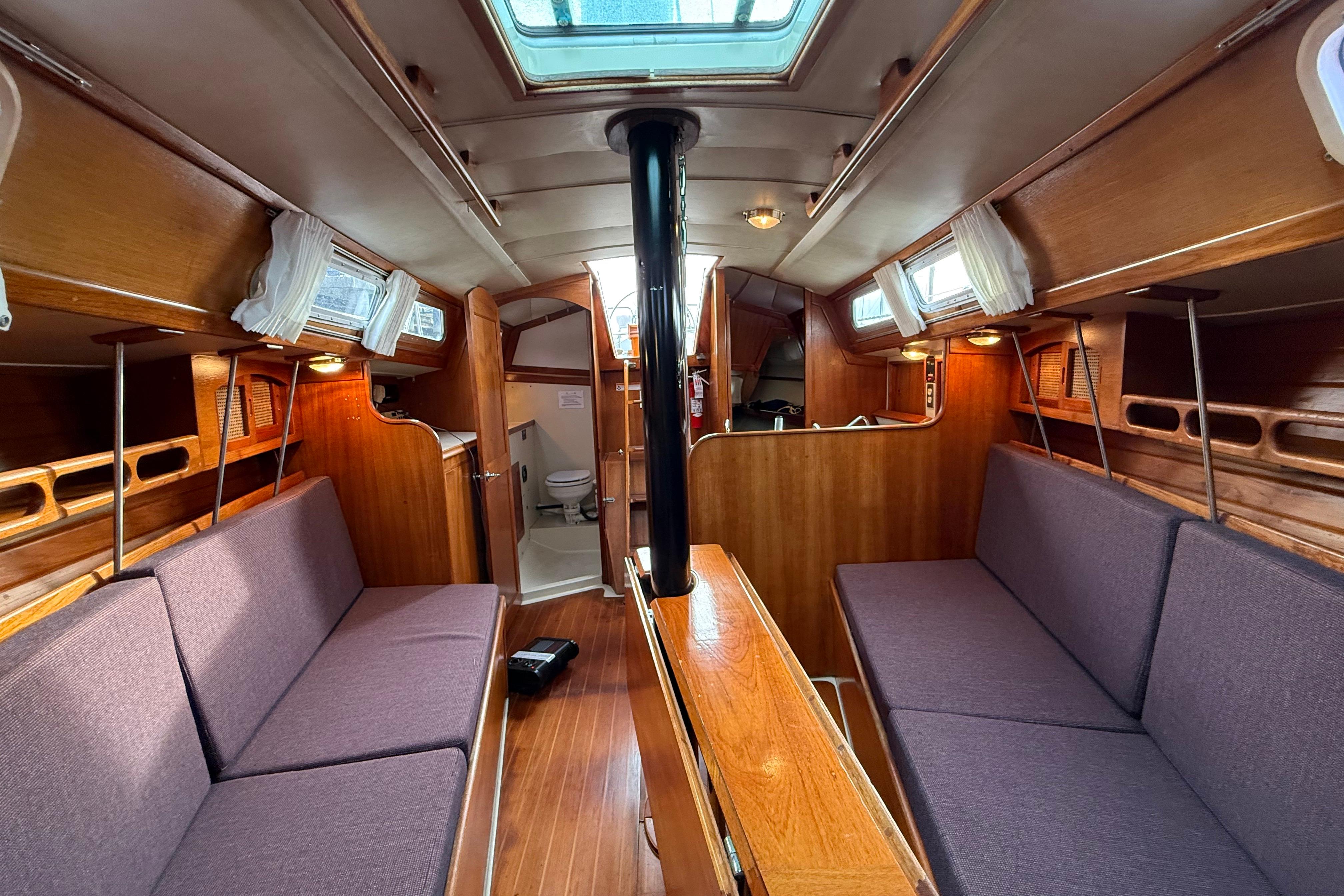 Interior of a 1988 Ericson 32-200 sailboat with wooden finishes and cozy seating.