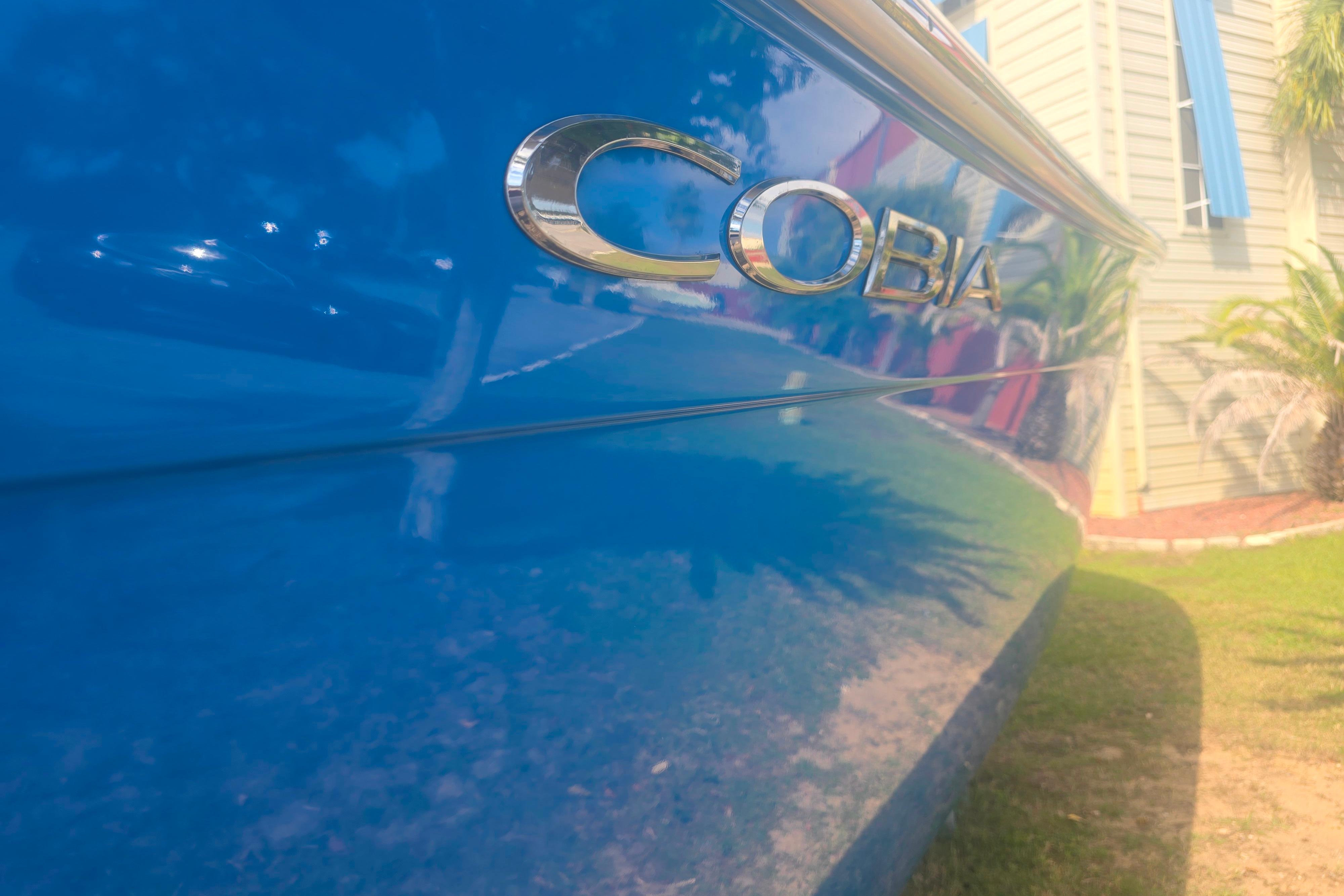 2017 Cobia 296 Center Console boat with shiny blue hull and logo.
