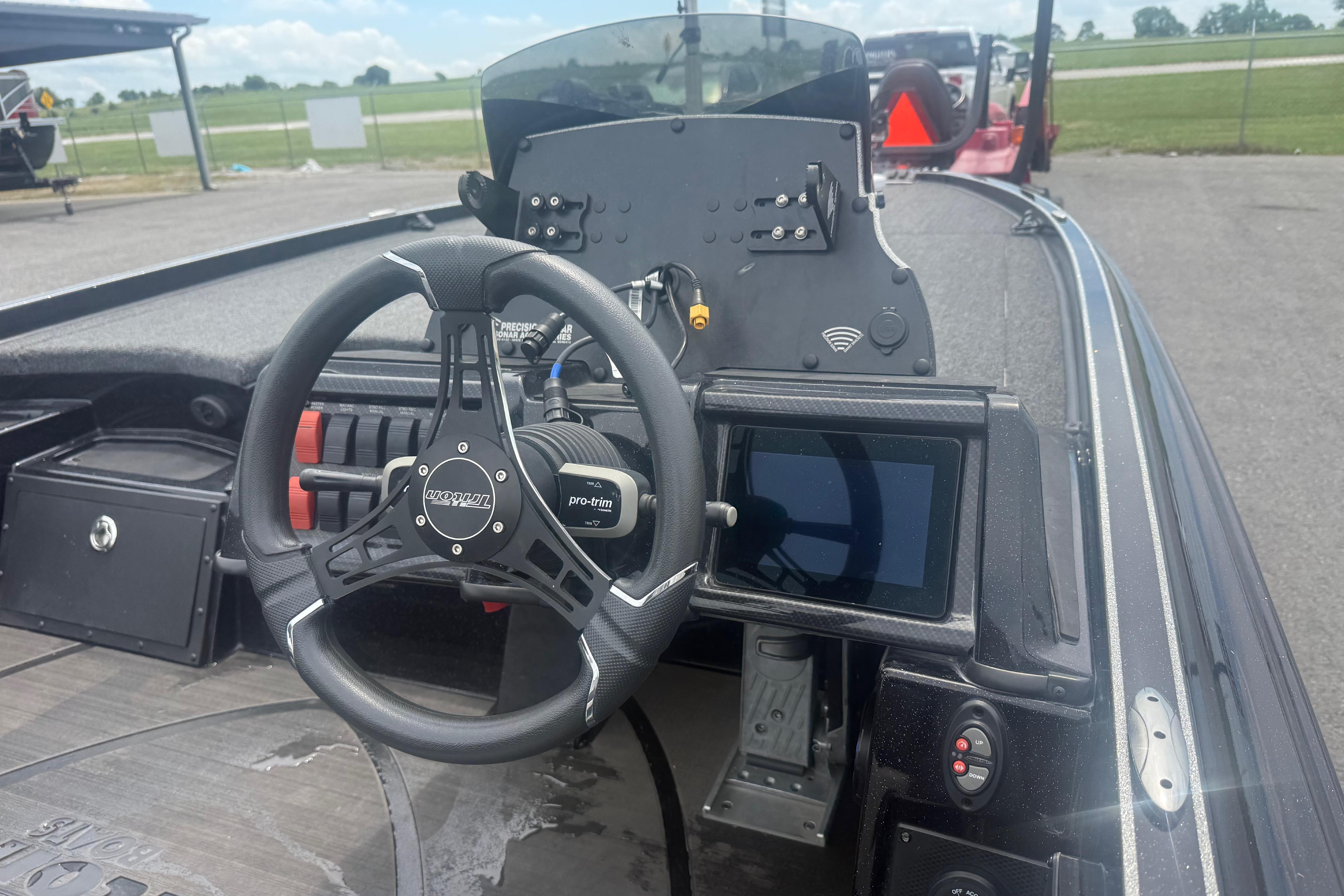 2024 Triton 20XP boat dashboard with steering wheel and digital display.