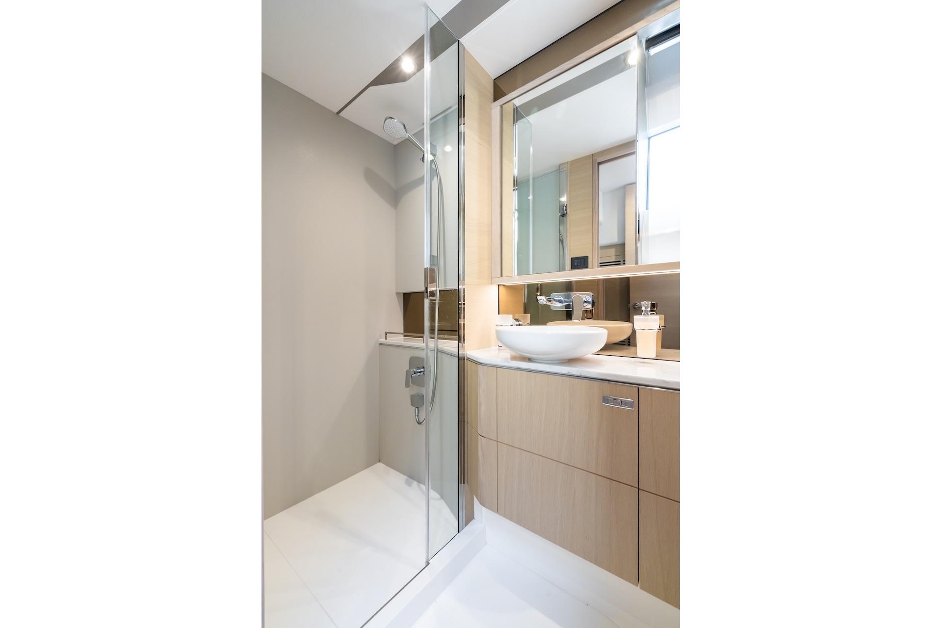 Modern bathroom in 2019 Princess V60 yacht with glass shower and sleek vanity.