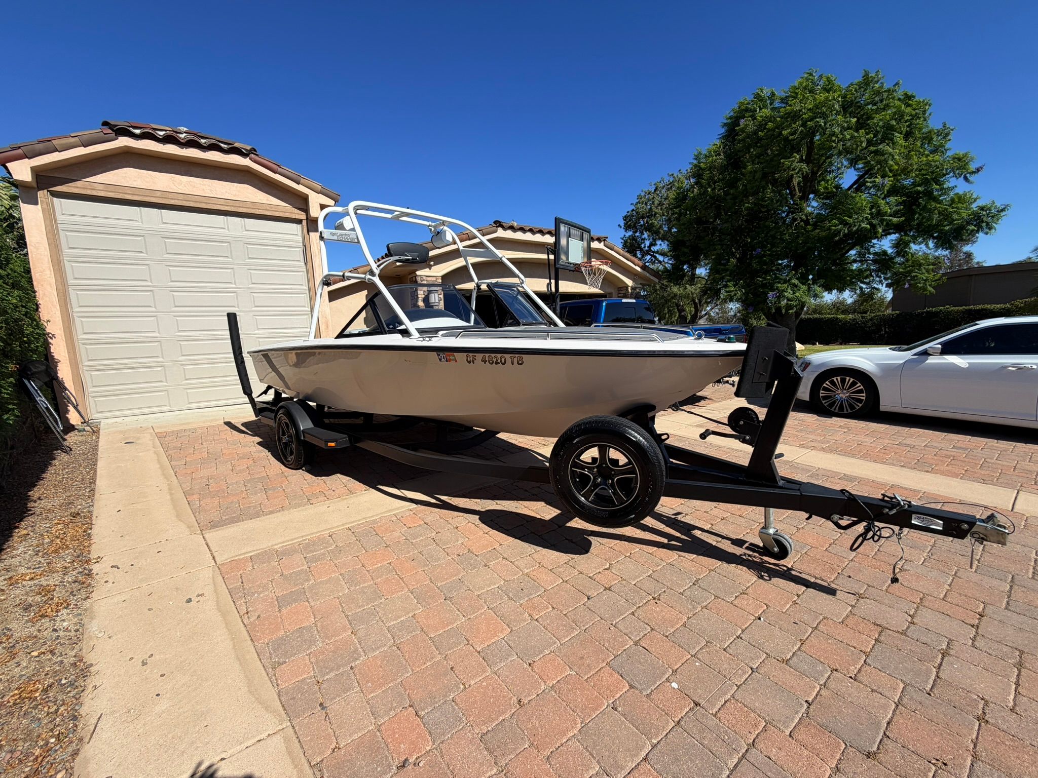 1996 Correct Craft Tournament boat on trailer in driveway.