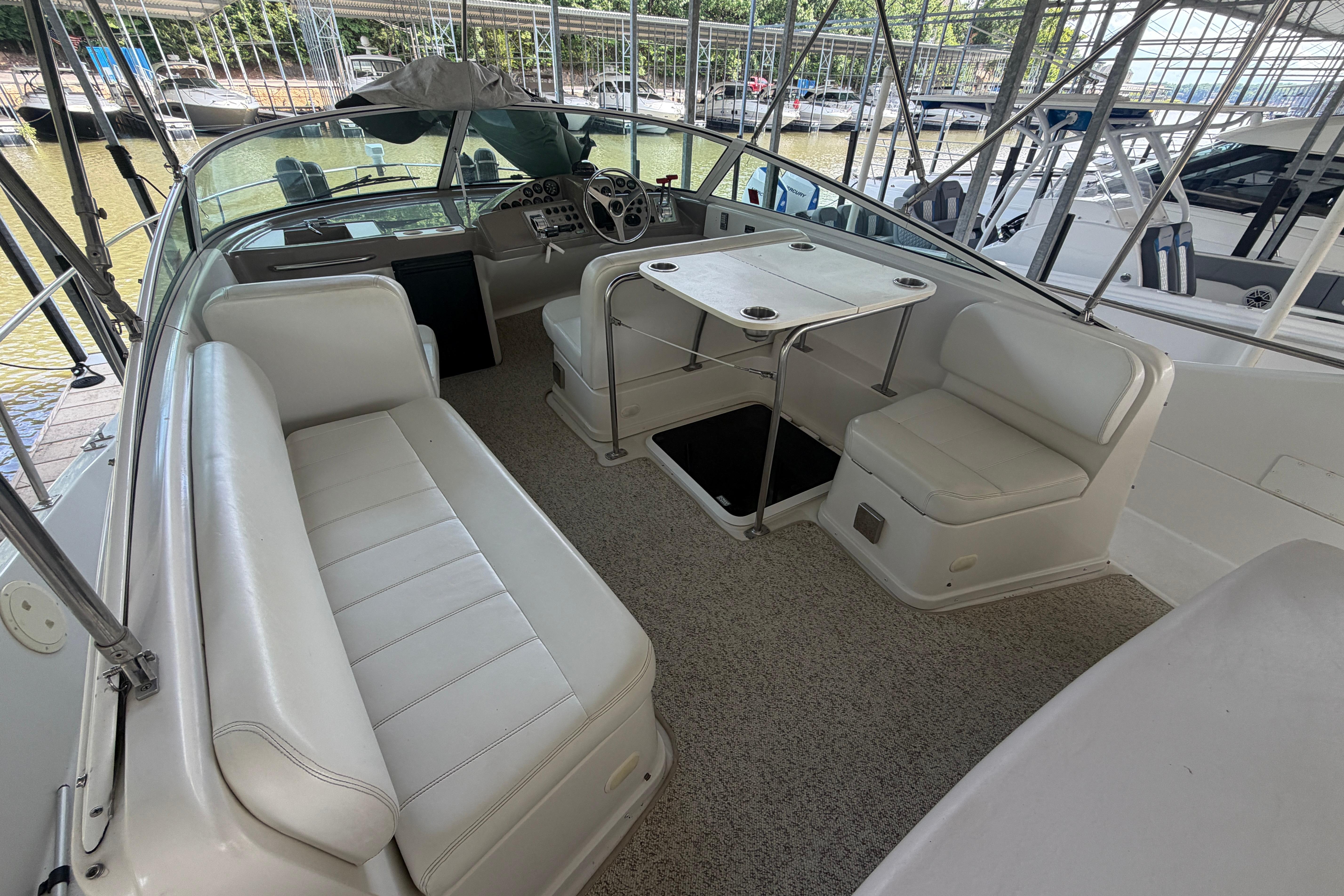 2000 Carver 350 Mariner boat interior with white seating and table in a marina setting.