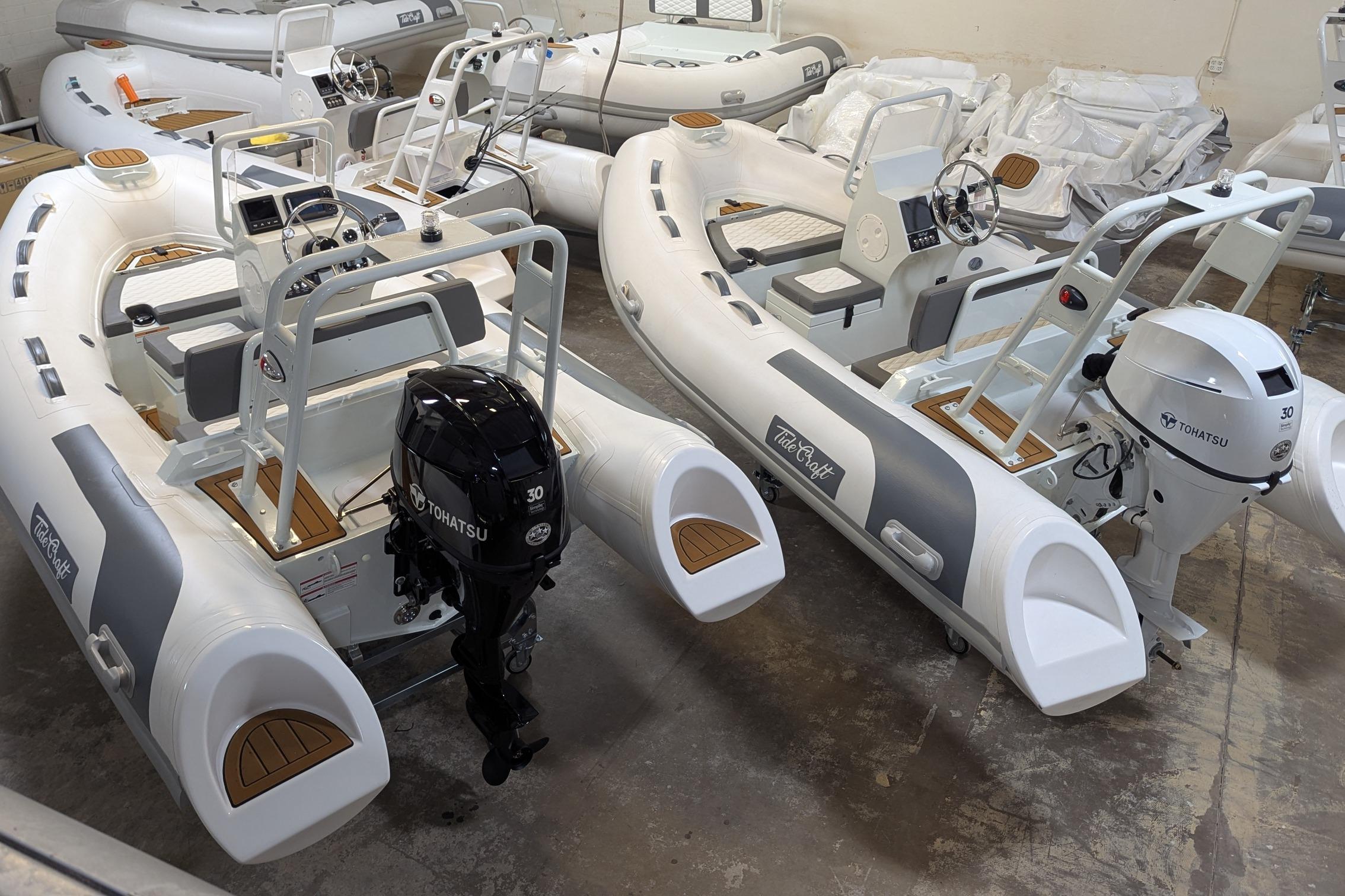 2027 Tide Craft San Juan 11 inflatable boats with Tohatsu engines in a showroom.