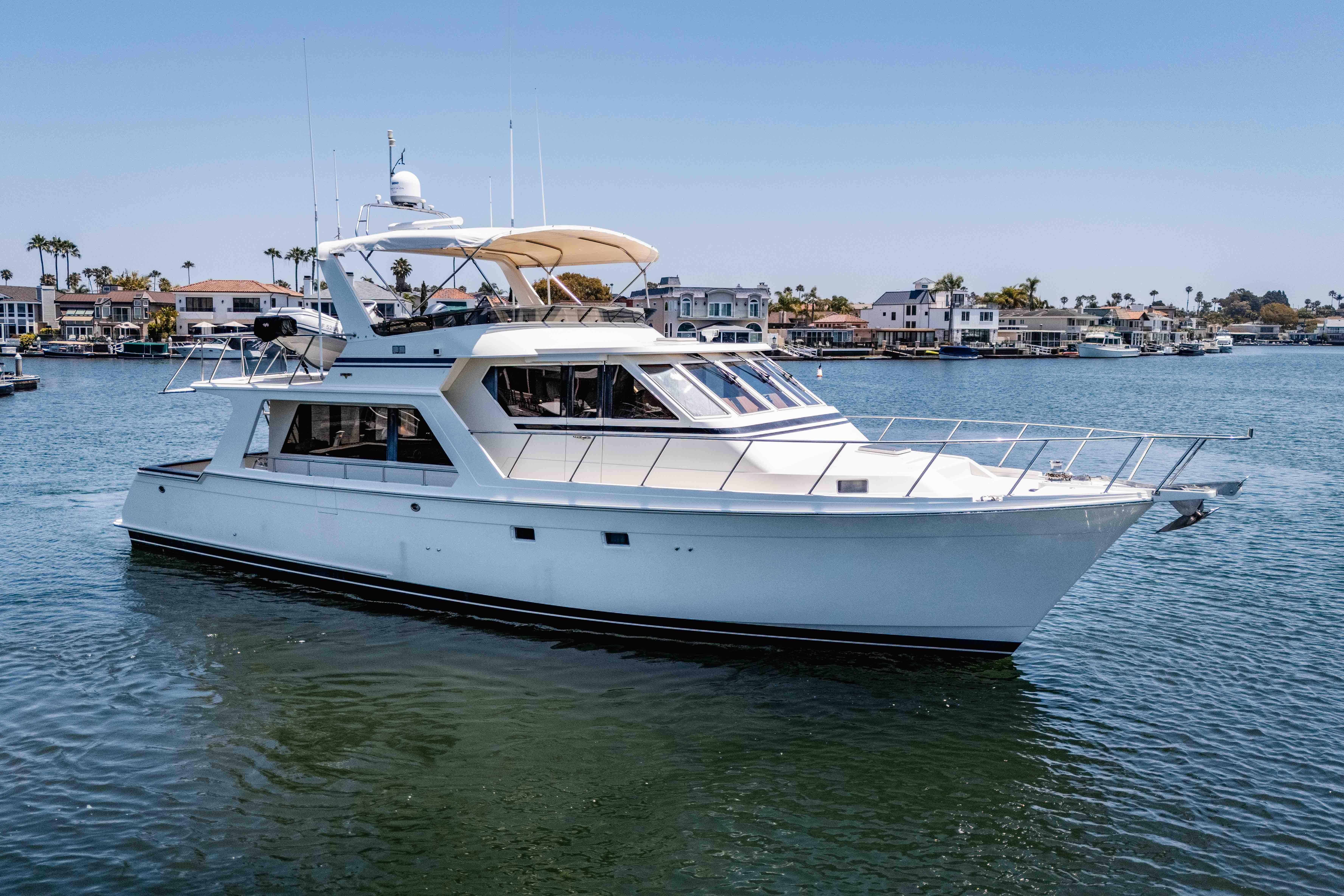 2005 Offshore Yachts 54 Pilothouse cruising in a scenic waterfront setting.