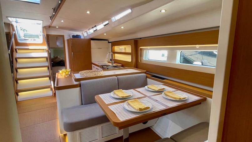 Modern interior of 2020 Beneteau First 53 yacht with dining area and staircase.