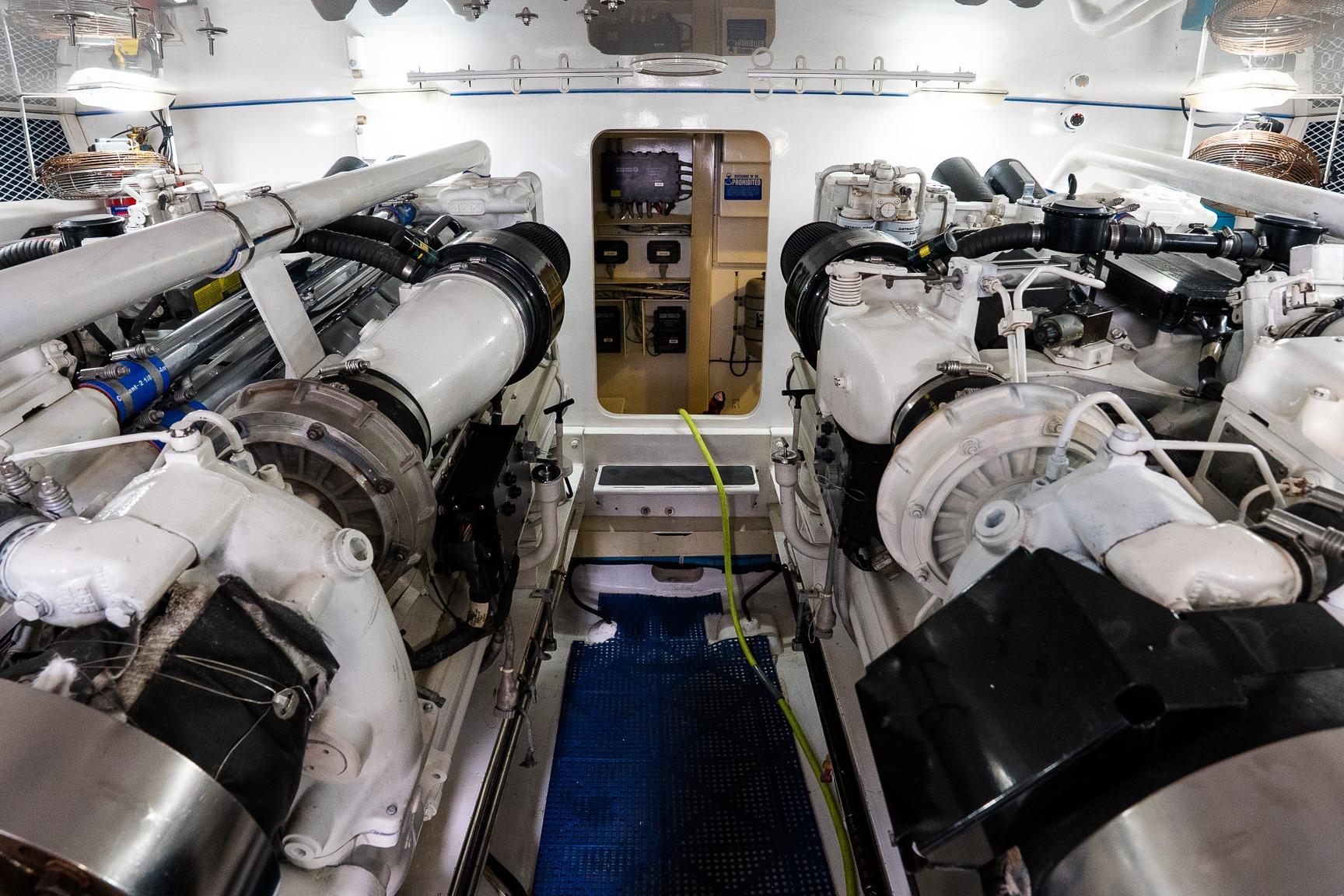 Engine room of 2002 Viking 61 Enclosed Bridge yacht, showcasing dual engines and mechanical systems.