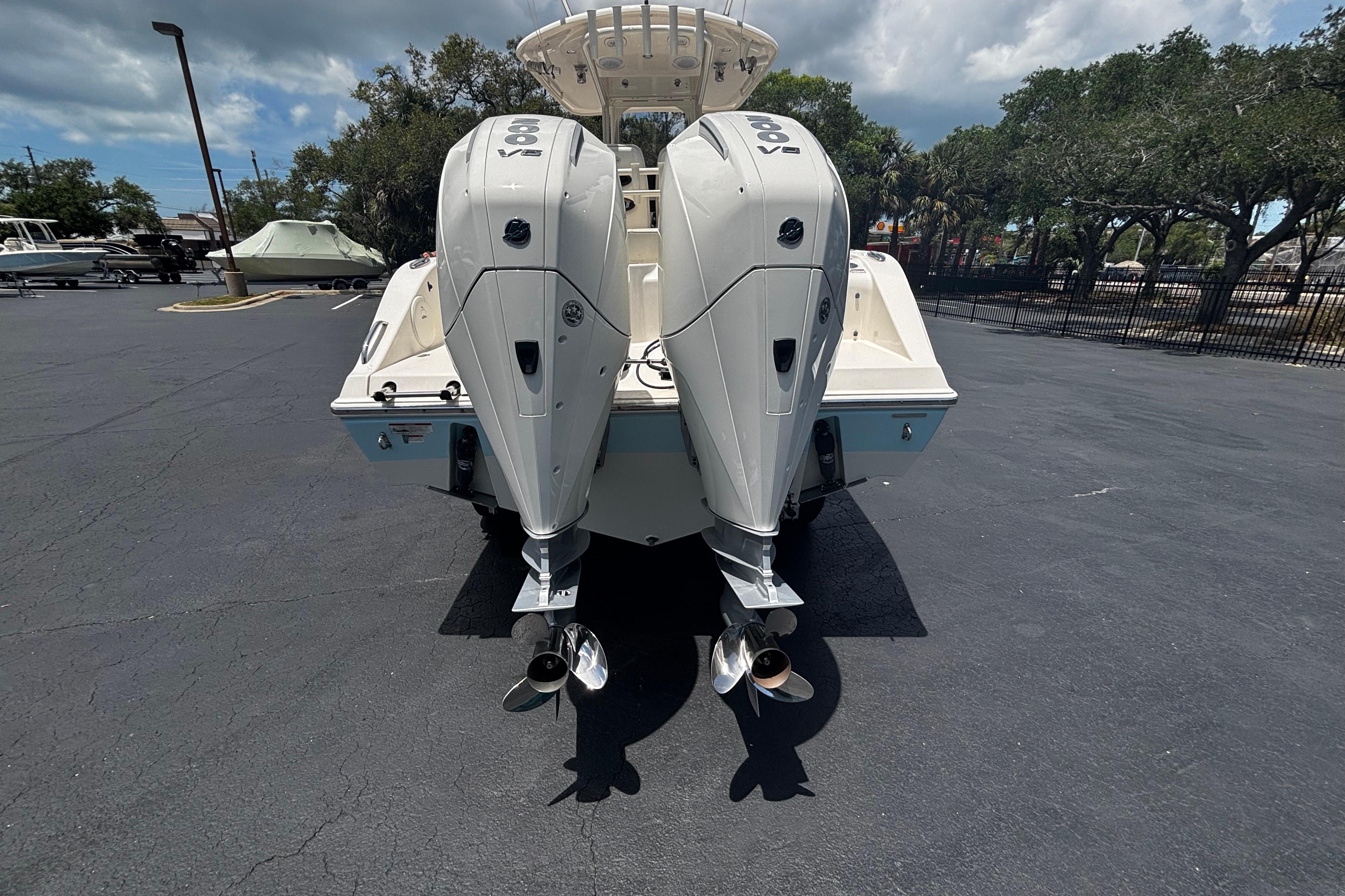 2023 Cobia 262 Center Console boat with dual outboard engines in a parking lot.