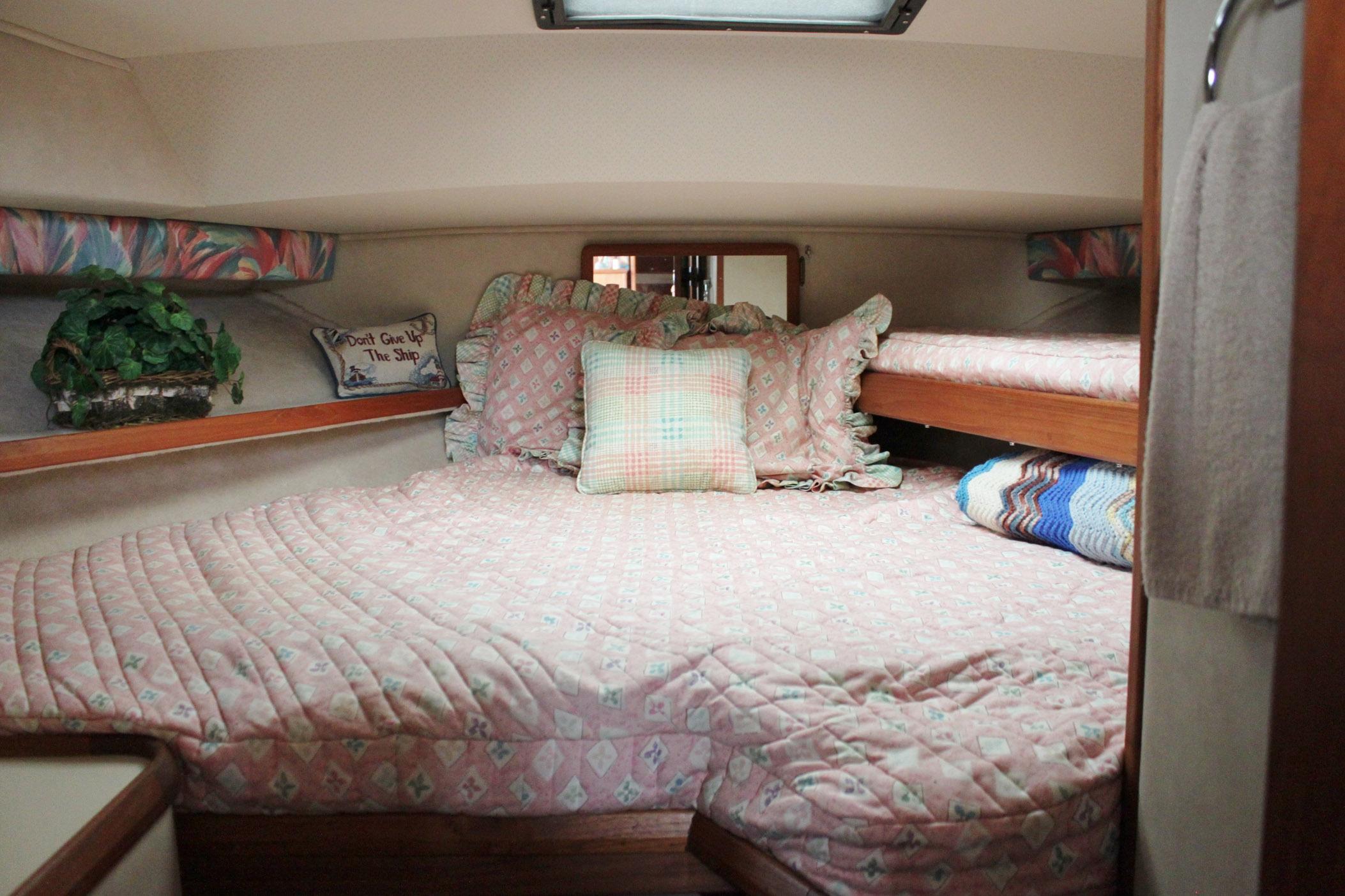 Cozy cabin interior of 1987 Chris-Craft 362 Catalina with patterned bedding and decor.