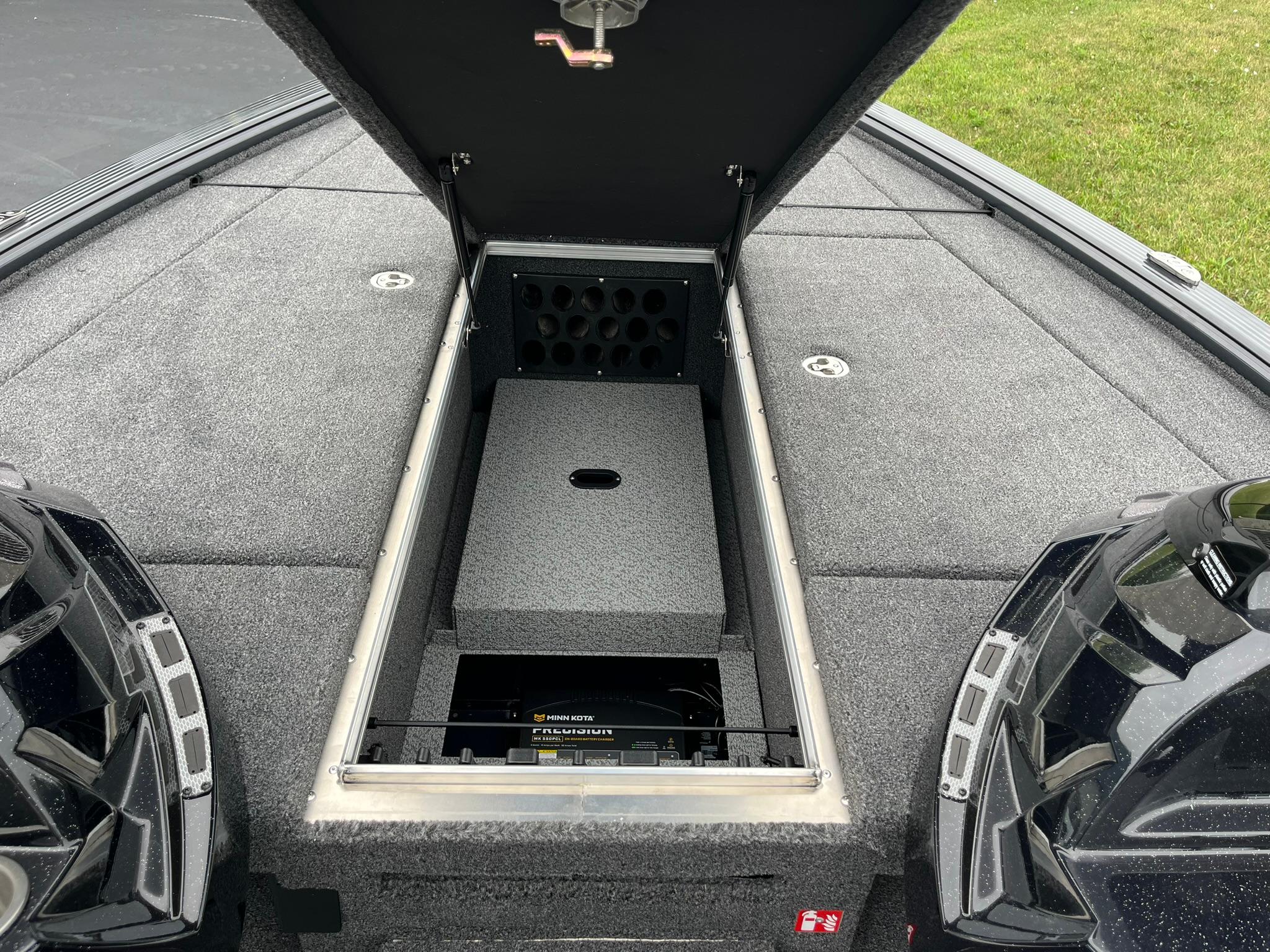 2026 Lund 1875 Pro-V Bass XS boat storage compartment with open lid, showcasing interior features.