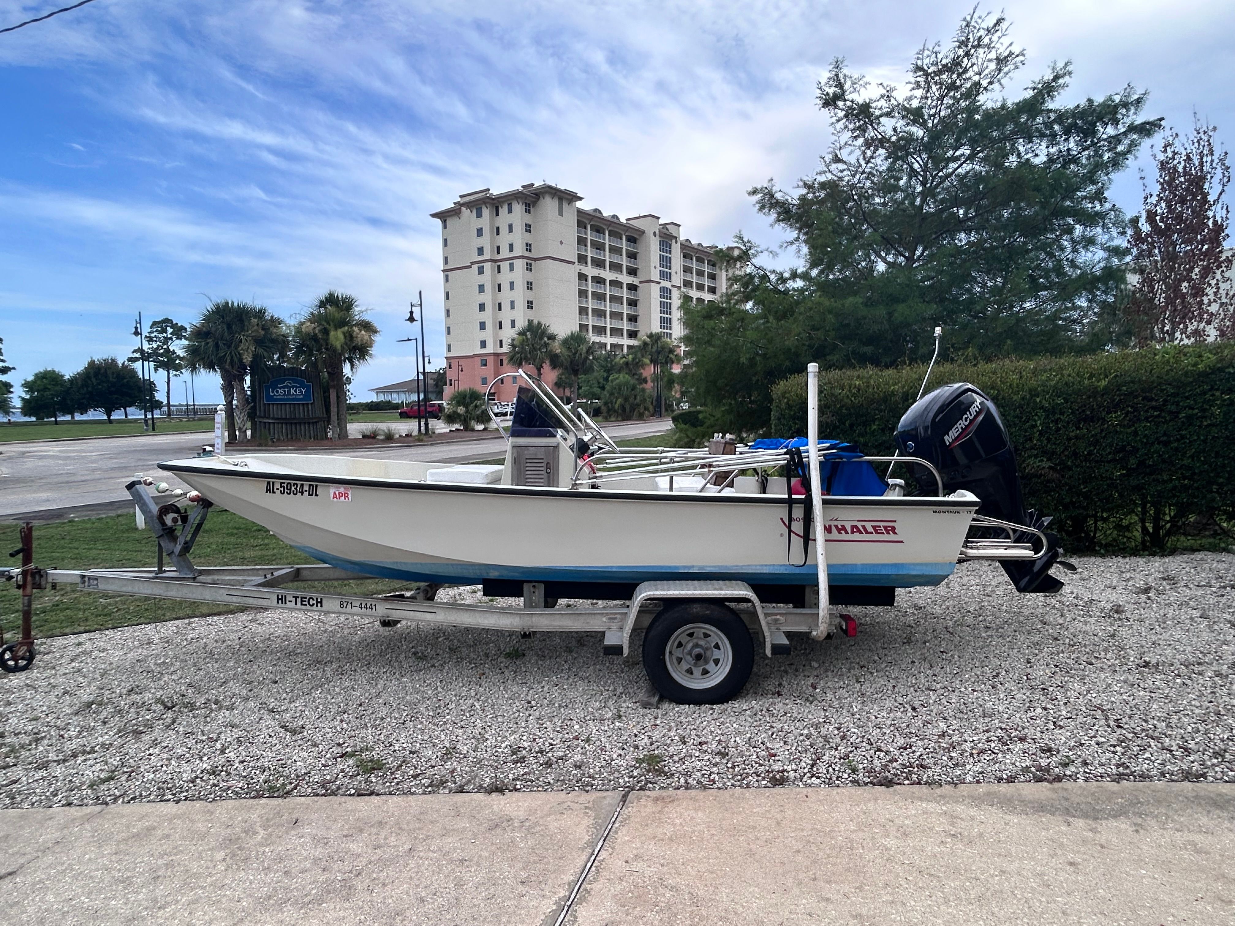 A 1984 Boston Whaler MONTAUK on a trailer in front of a building.