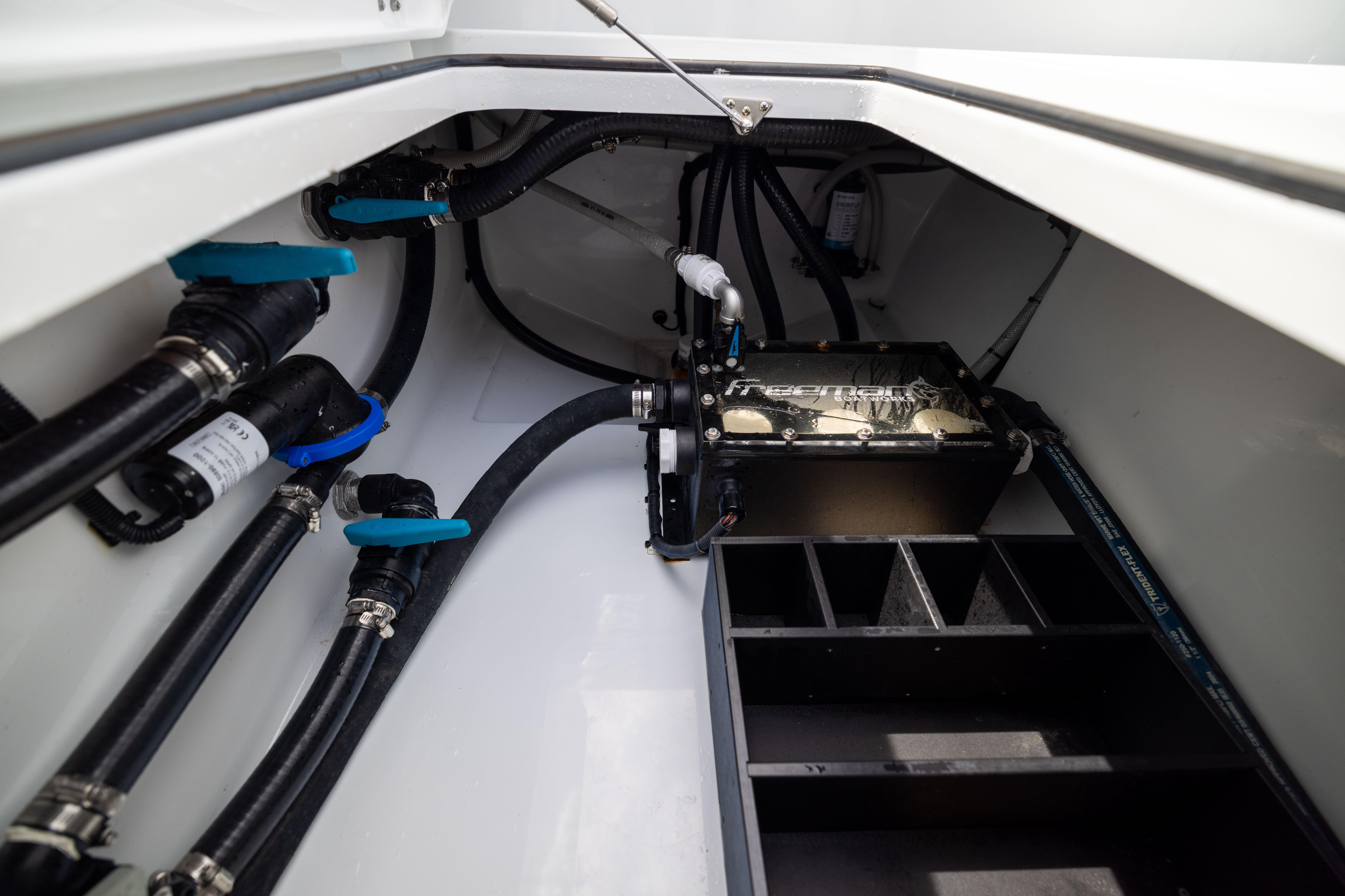 Engine compartment of 2025 Freeman 42 LR boat, showcasing pipes and mechanical components.