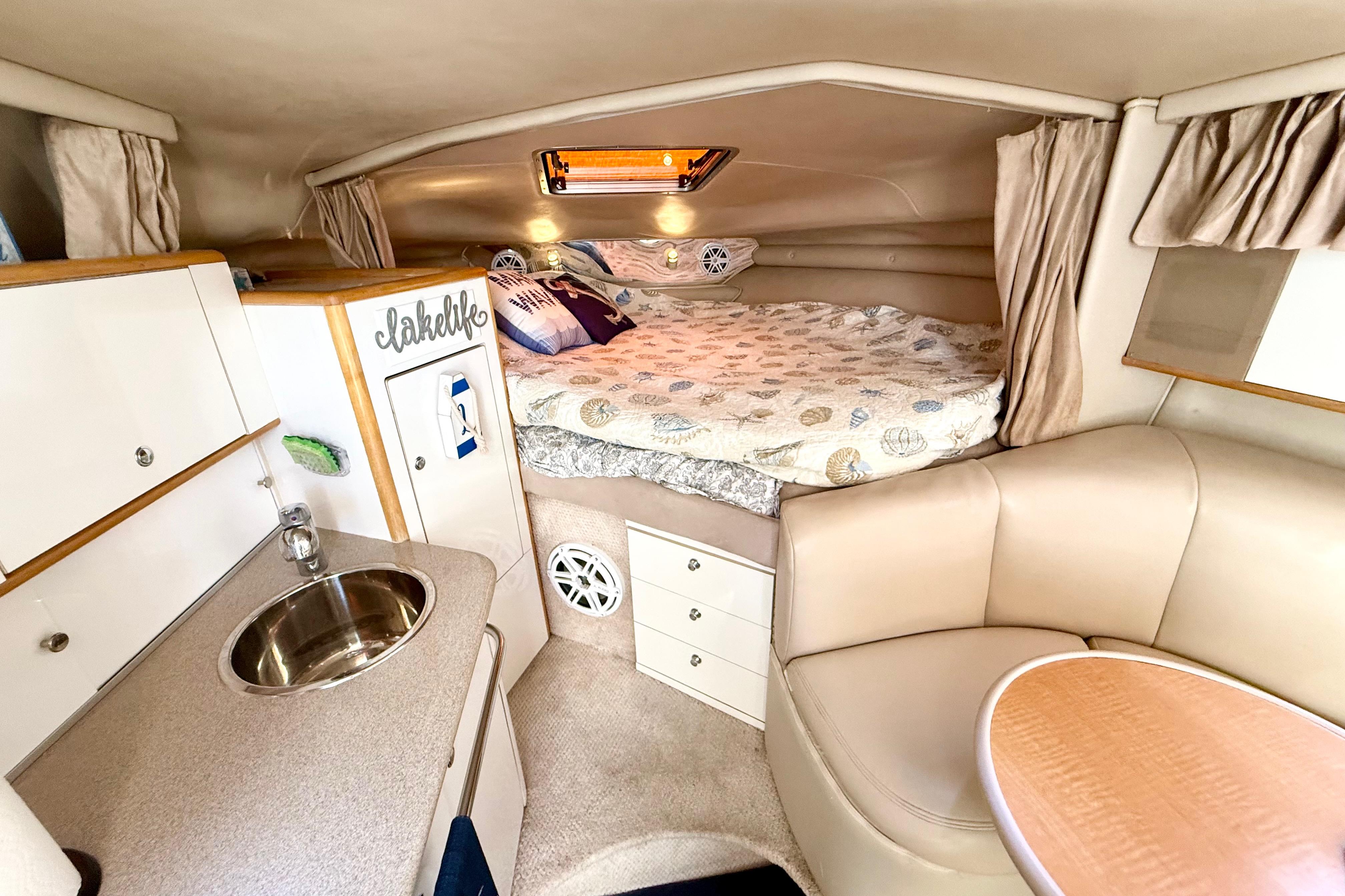 1999 Chaparral Signature 300 cabin interior with cozy bed, kitchenette, and seating area.
