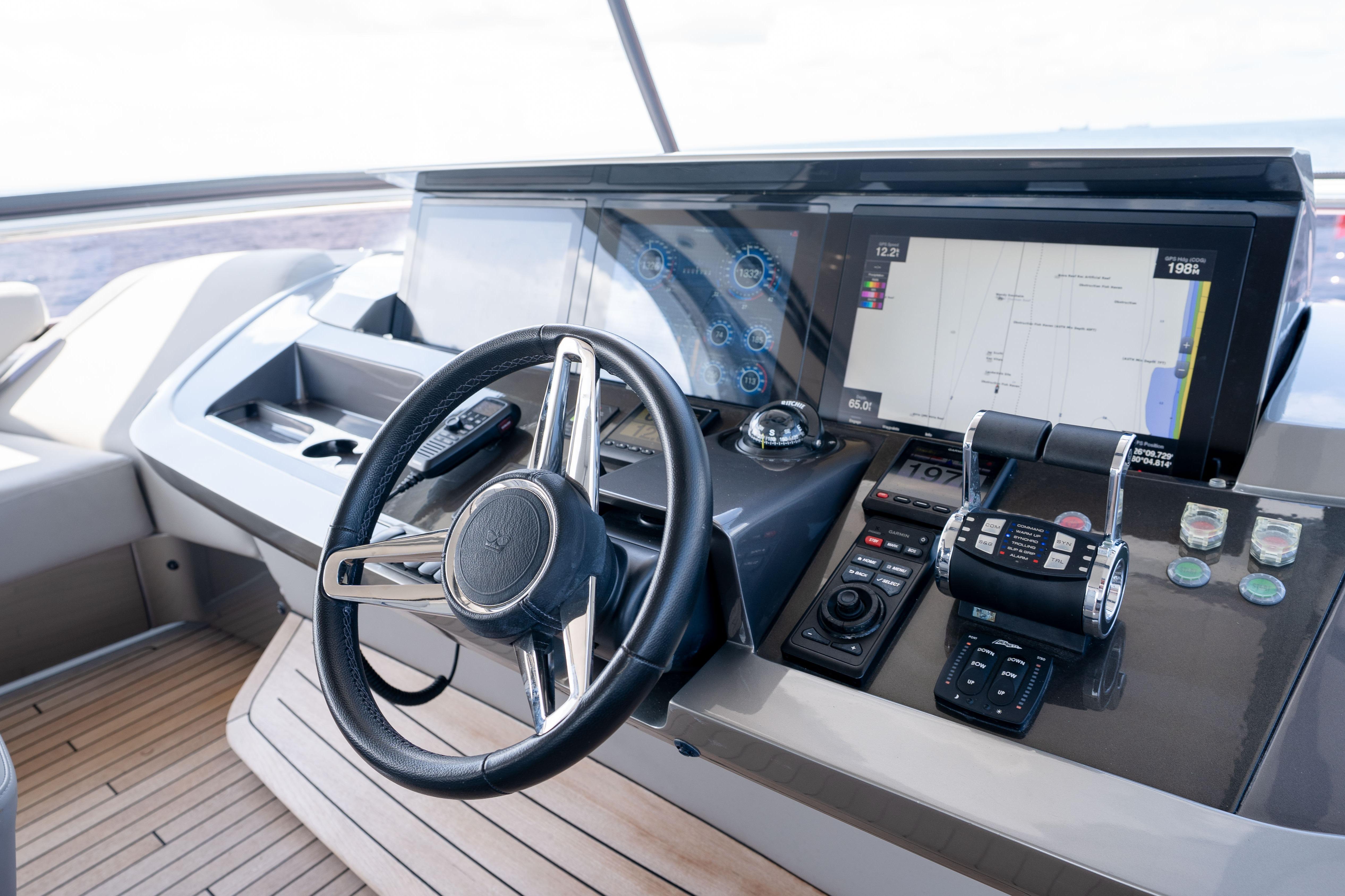 Cockpit of 2020 Princess Y85 yacht with steering wheel and navigation controls.