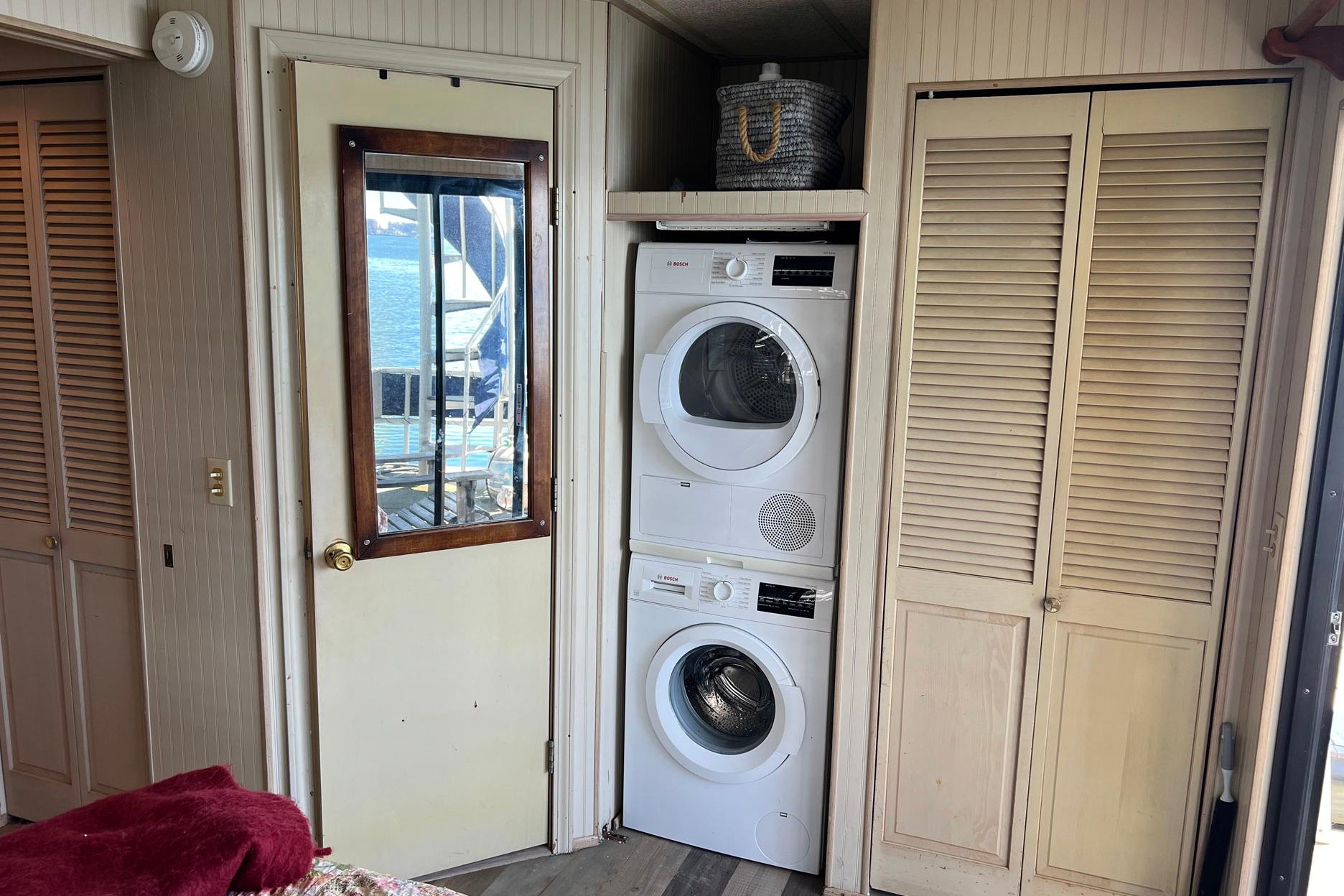 Laundry area inside a 1993 Sumerset houseboat with stacked washer and dryer.