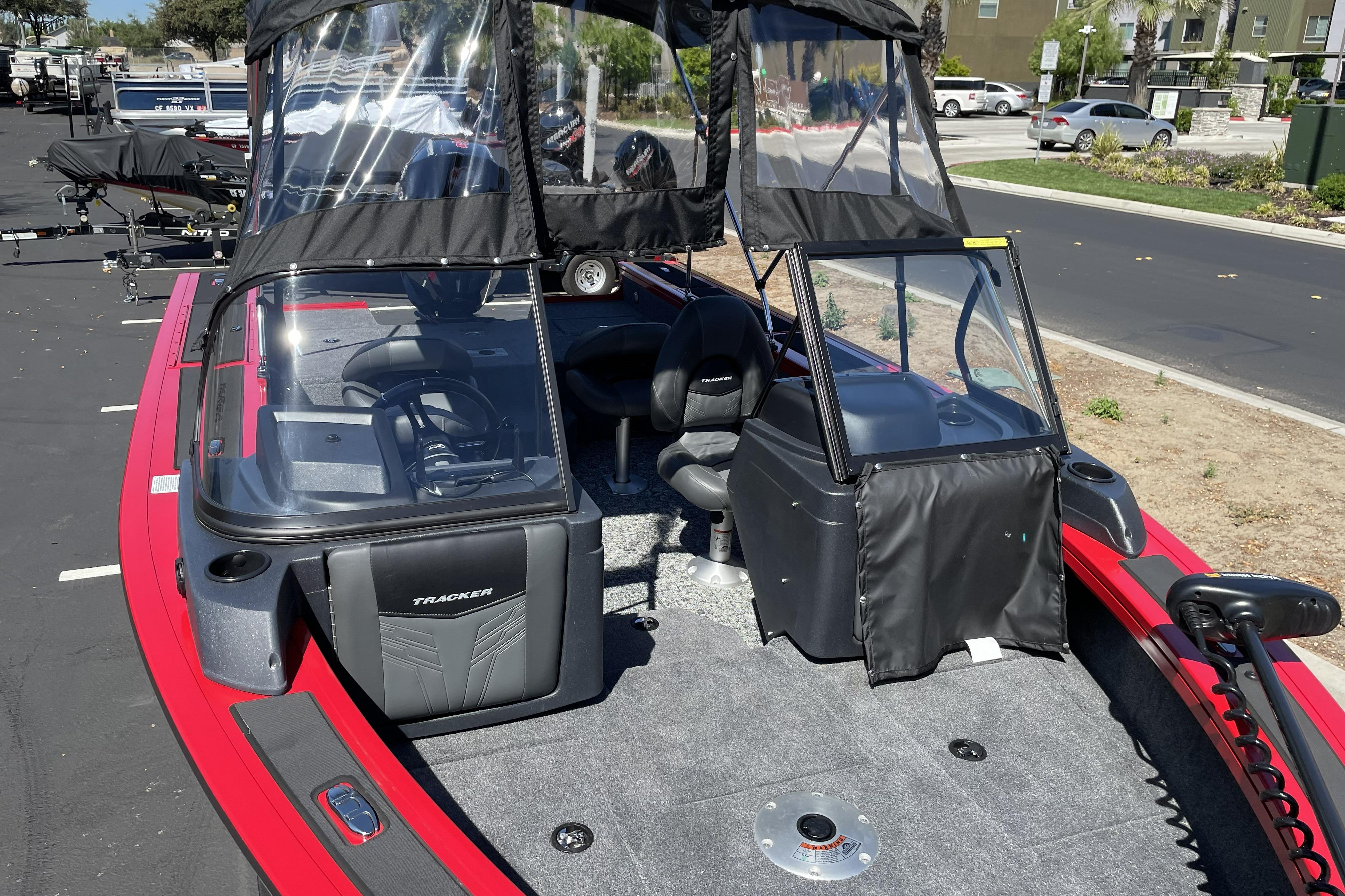 2026 Tracker Targa V-18 WT boat with canopy, parked on pavement.