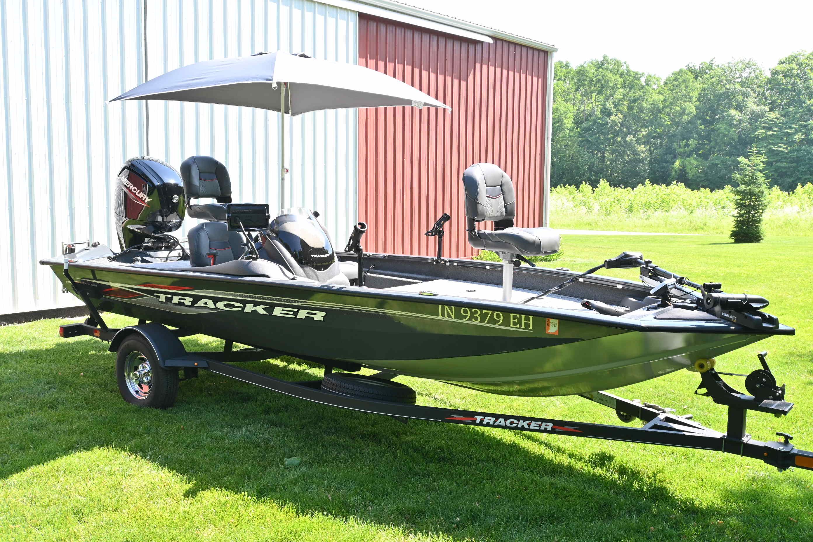 2022 Tracker Pro 175 TF on a trailer with an umbrella, parked in front of a building.