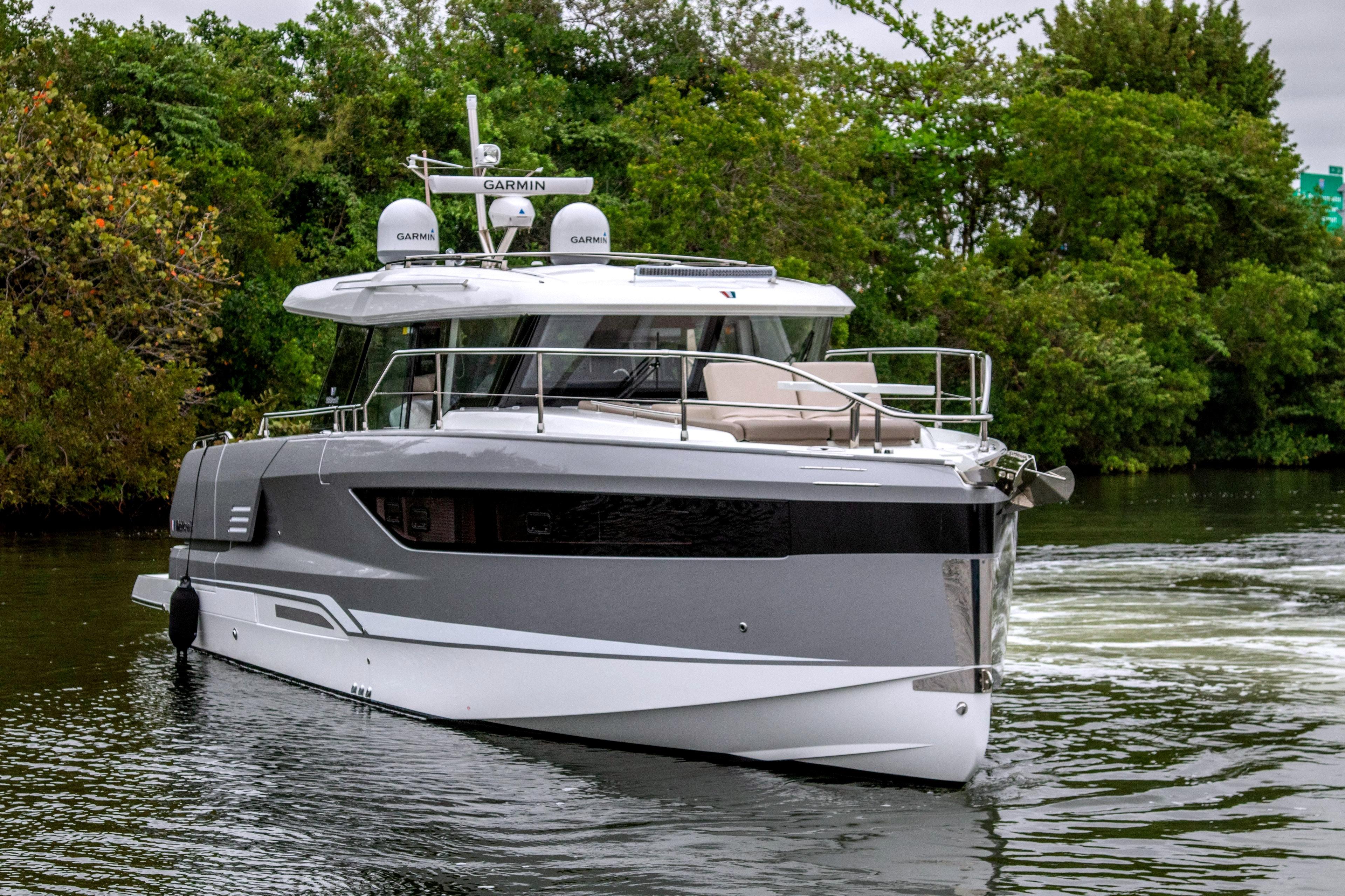 2026 Wellcraft 44 Explorer yacht on calm water with lush greenery backdrop.