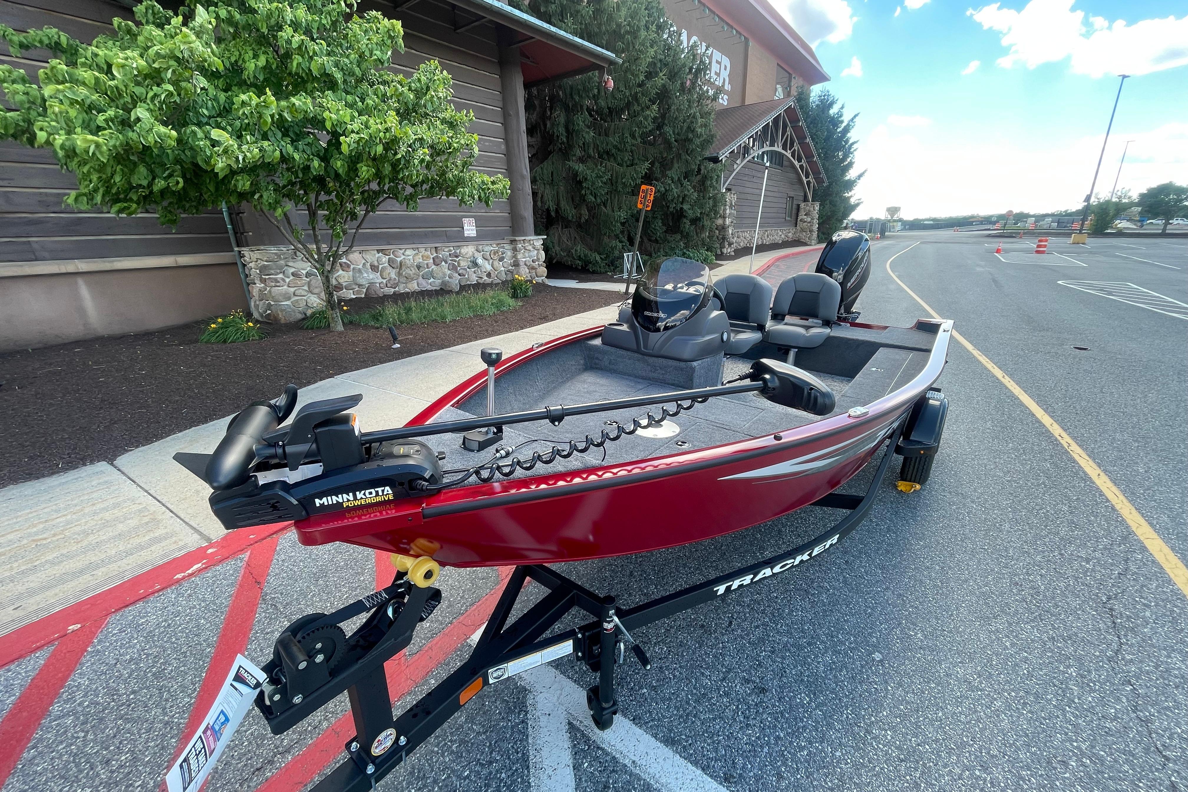 2026 Tracker Super Guide V-16 SC fishing boat on trailer, parked outdoors.