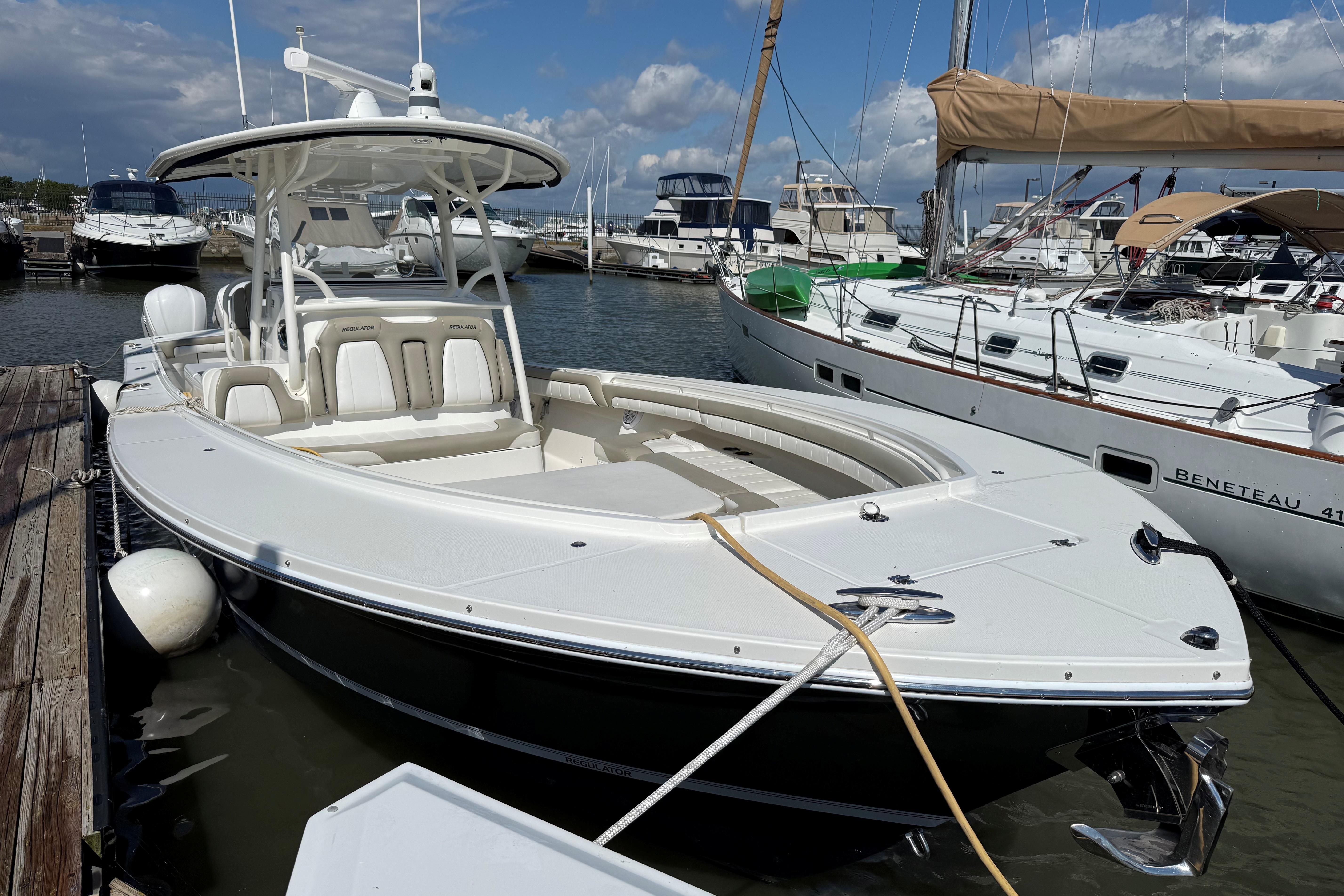 2019 Regulator 34SS boat docked at marina, surrounded by other vessels under a partly cloudy sky.